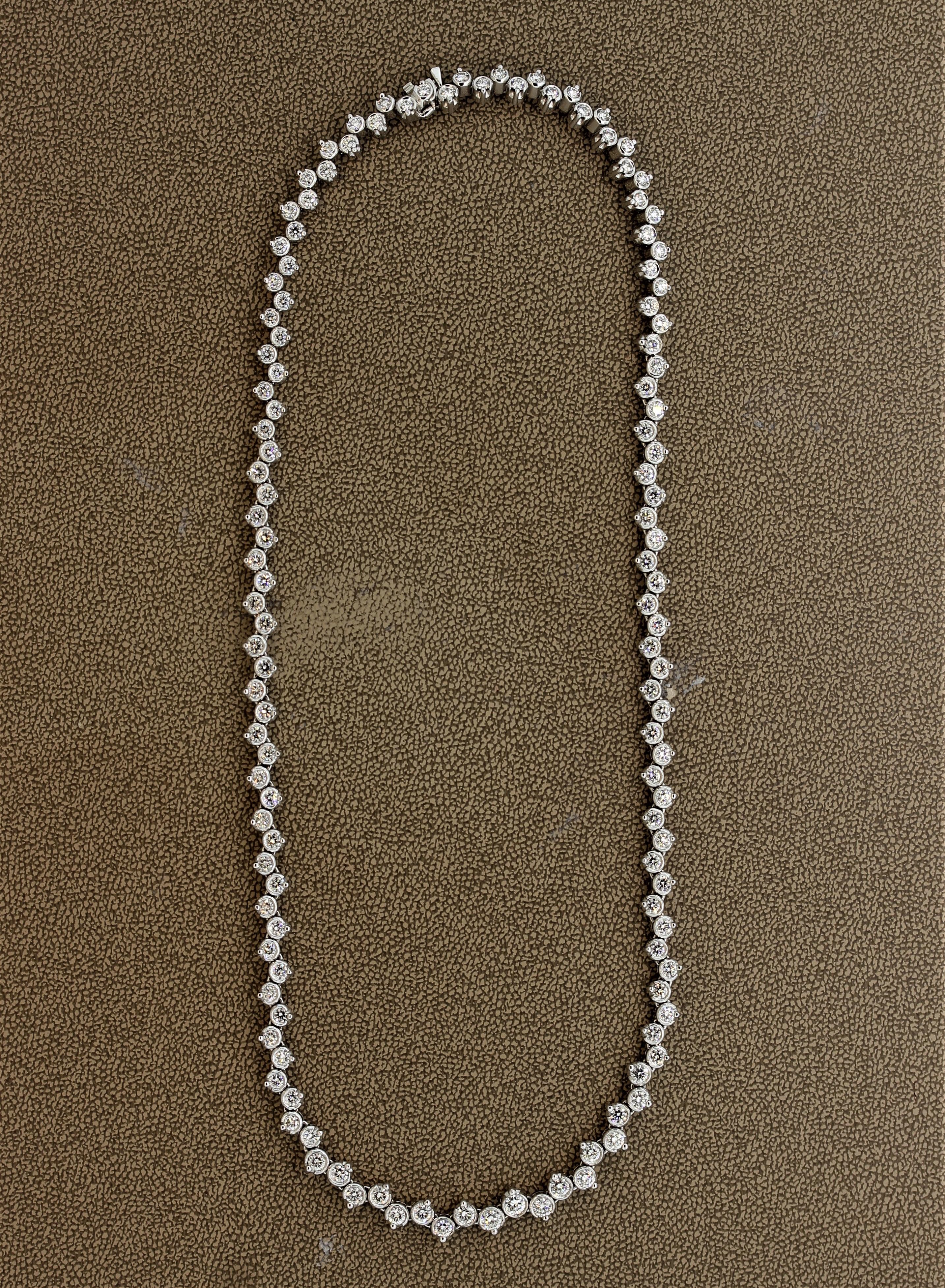 A modern take on the classic tennis necklace. This piece features 8.76 carat of fine round brilliant cut diamonds which are set in a unique bezel and prong setting combination. Most of the diamonds are bezel-set (gold wrapping around the edges of