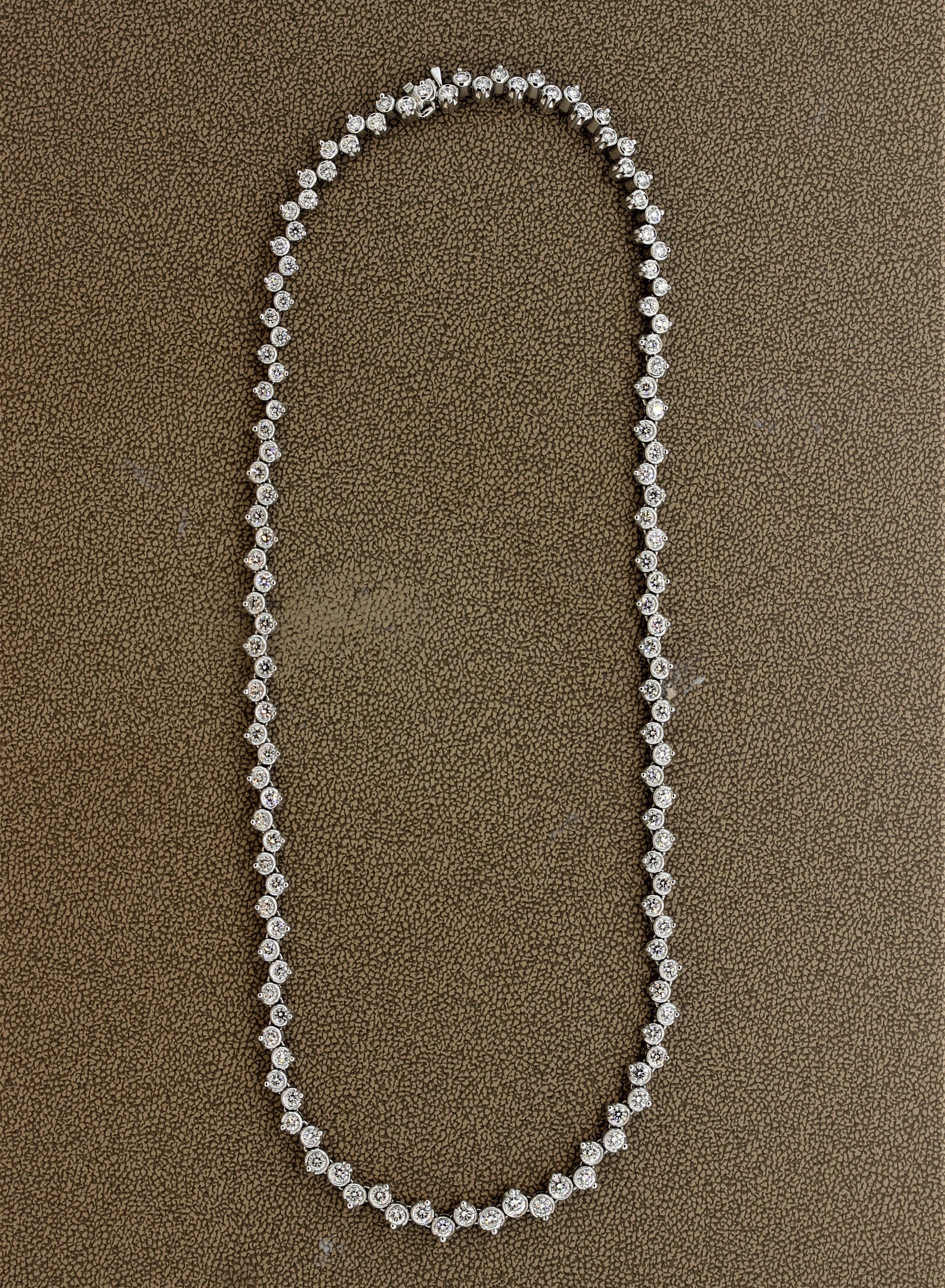 A modern take on the classic tennis necklace. This piece features 8.76 carat of fine round brilliant cut diamonds which are set in a unique bezel and prong setting combination. Most of the diamonds are bezel-set (gold wrapping around the edges of