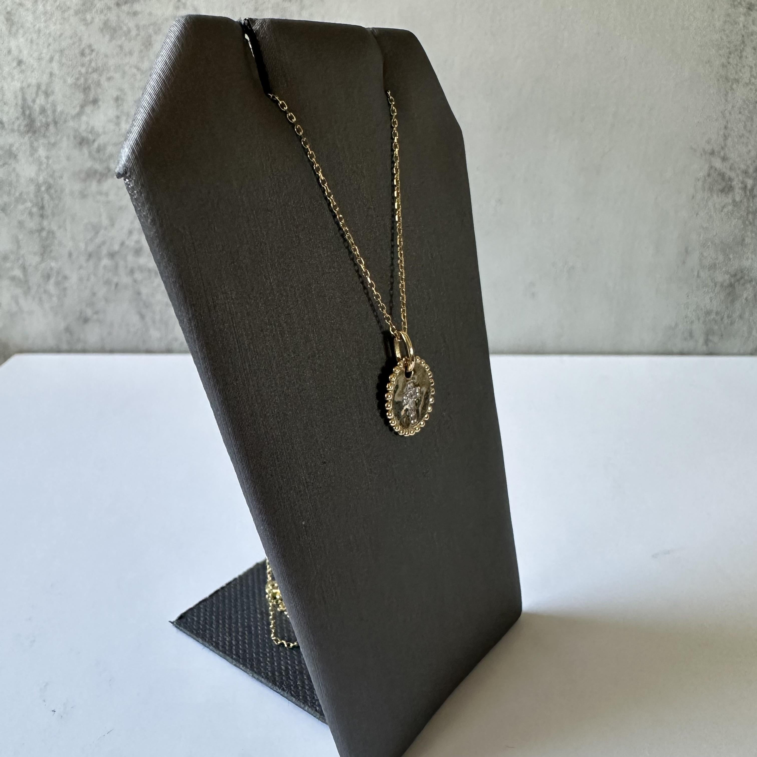 Ce collier raffiné présente un pendentif délicat façonné en or jaune 10k, mettant en valeur des diamants blancs en son centre. Les diamants, d'un poids de 0,03 carat, sont taillés dans un seul style et classés GH pour la couleur avec une clarté I1,