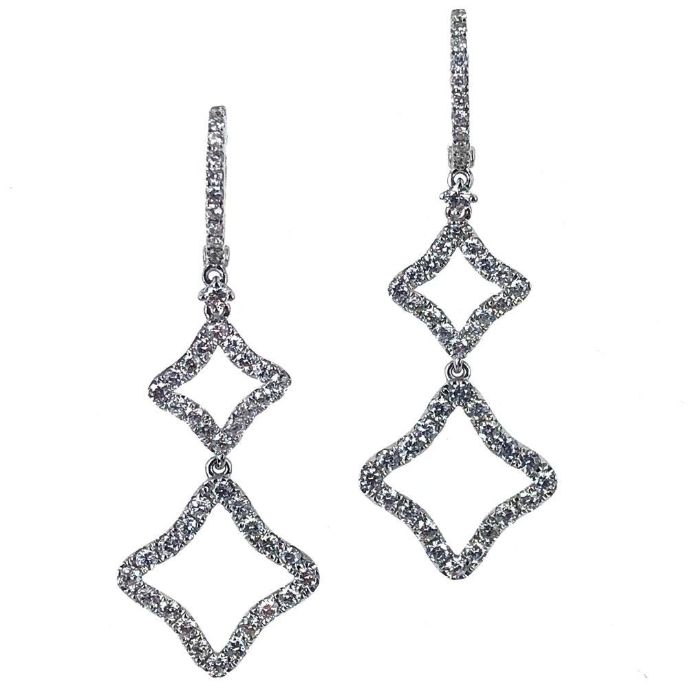 These sleek diamond drop earrings are fashioned in 18 karat white gold. Round brilliant cut diamonds (1.63 carat total weight) sparkle in these quatrefoil shape drops. The diamonds are graded H-I color and SI1-2 clarity. The earrings measure 40mm in
