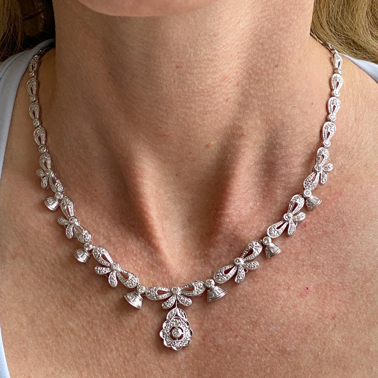 This fabulous diamond link necklace is crafted in 18 karat white gold. The necklace features 4.00 carats of baguette and round brilliant cut diamonds. The diamonds are graded G-H color and VS2-SI clarity.  The diamond floral drop measures .70 inches