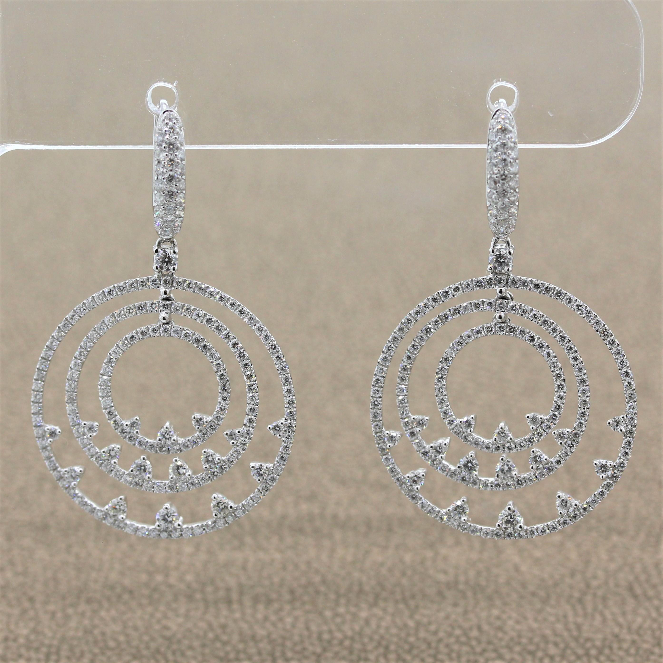 A fun pair of drop earrings with three graduating hoops. The free-flowing halos are studded with 2.23 carats of round brilliant cut diamonds with a diamond design on the inside portion of each halo in an 18K white gold setting. A true piece of fine