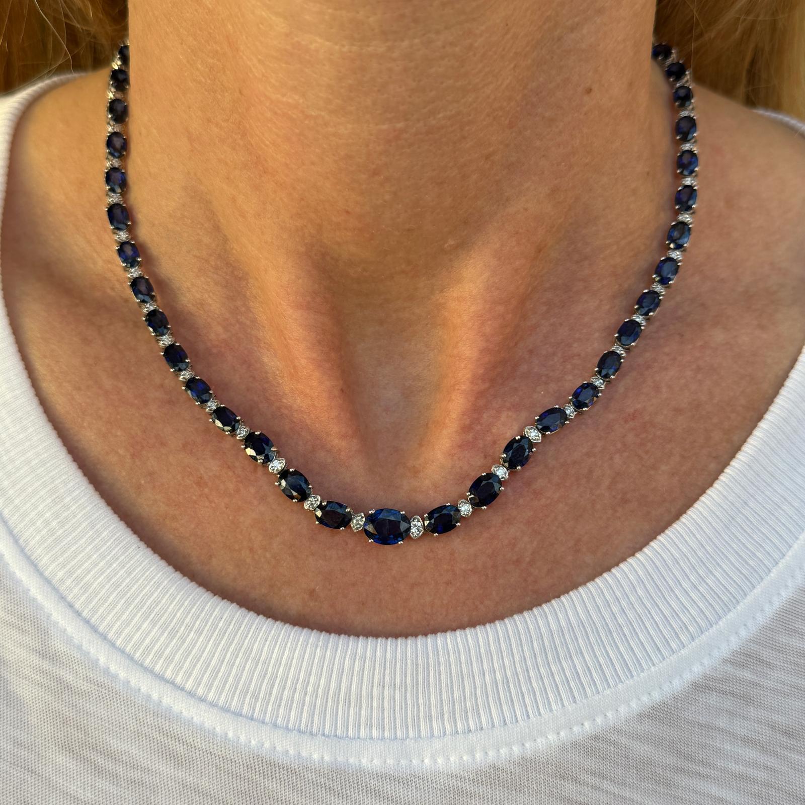 Modern oval sapphire and diamond necklace fashioned in 14 karat white gold. The necklace features 51 oval natural blue sapphires weighing approximately 30 carat total weight and 51 round brilliant cut diamonds weighing approximately 1.10 carat total
