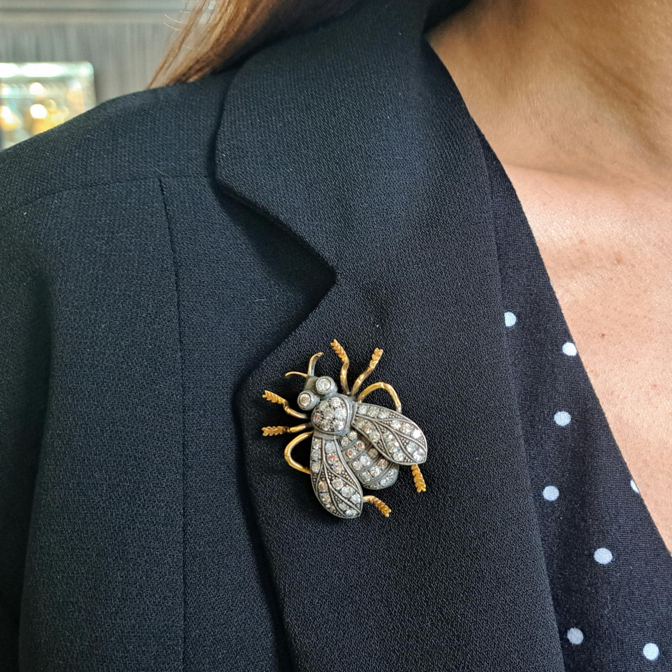A modern bee brooch, set with eight-cut and round brilliant-cut diamonds in the wings, thorax, abdomen and head, with millegrain edges and wing markings, mounted in silver-upon-gold, with gold legs and antennae.