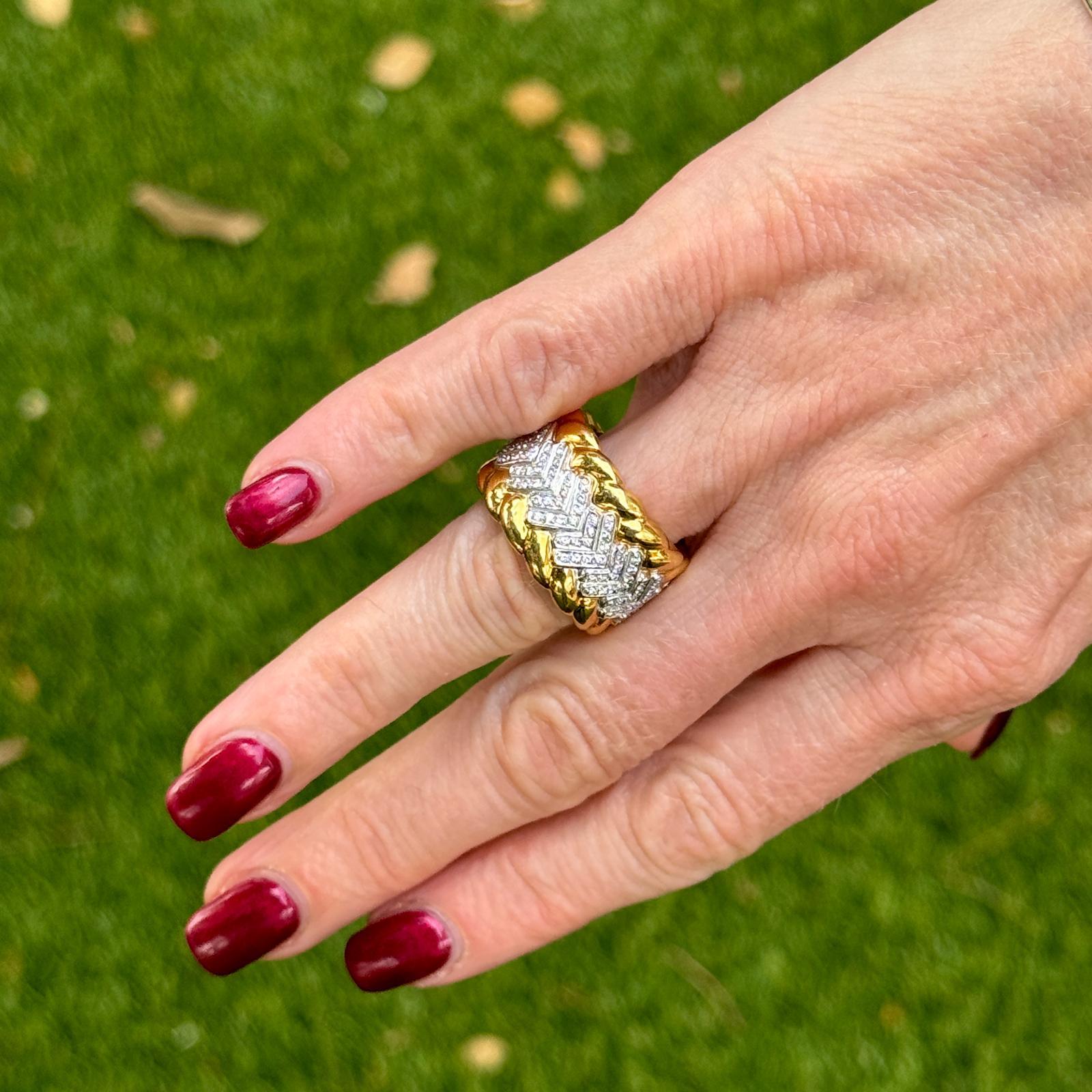 This elegant wide band ring is crafted from 18 karat yellow gold with a distinctive textured design, offering a luxurious and timeless look. Set down the center of the ring are round brilliant diamonds with a total weight of approximately 0.90