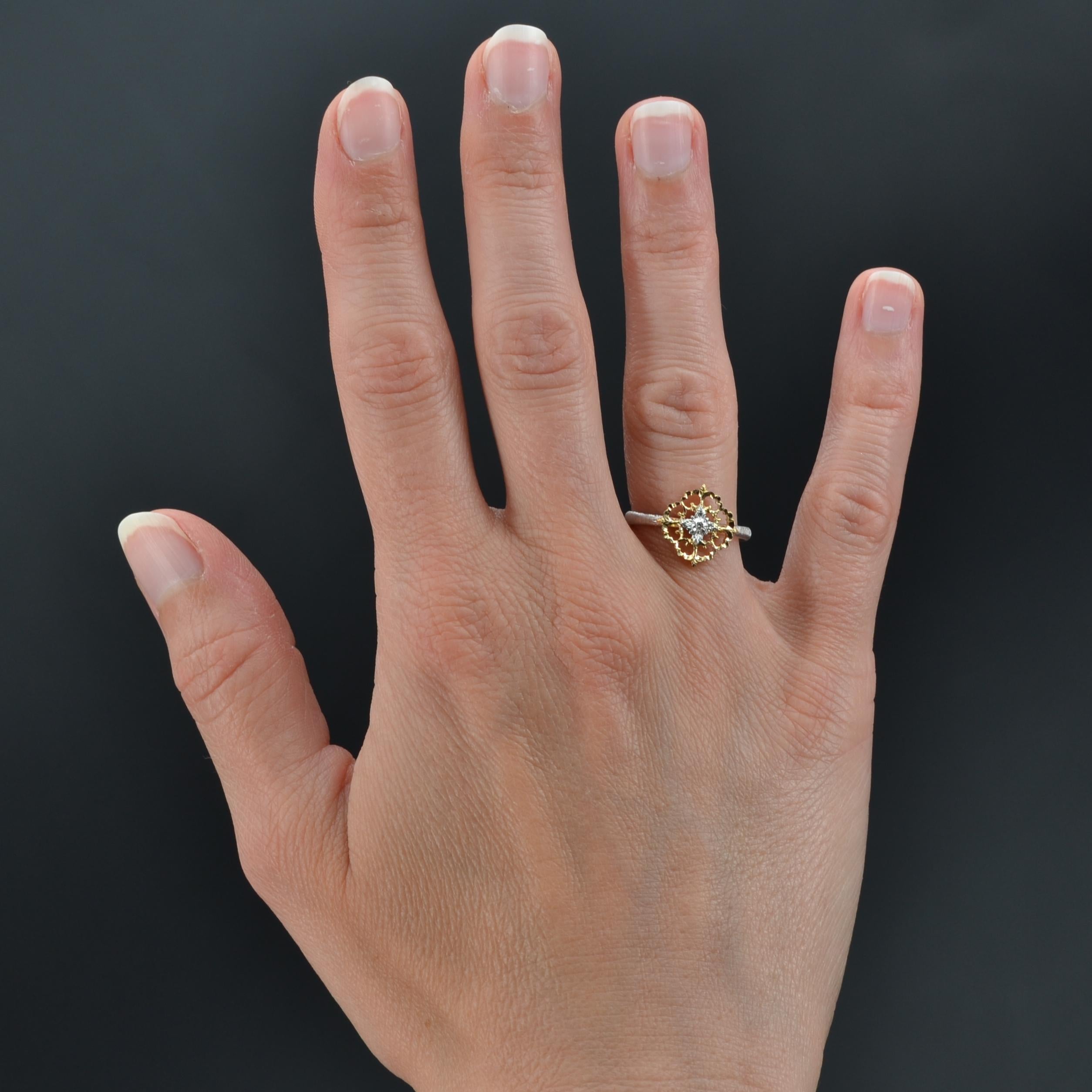 Ring aus 18 Karat Gelb- und Weißgold.
Dieser charmante Ring aus 2 Goldarten besteht aus einem flachen, gebohrten Muster, das mit Arabesken gemeißelt und mit einem modernen Diamanten im Brillantschliff verziert ist. Der Ring ist aus ziseliertem