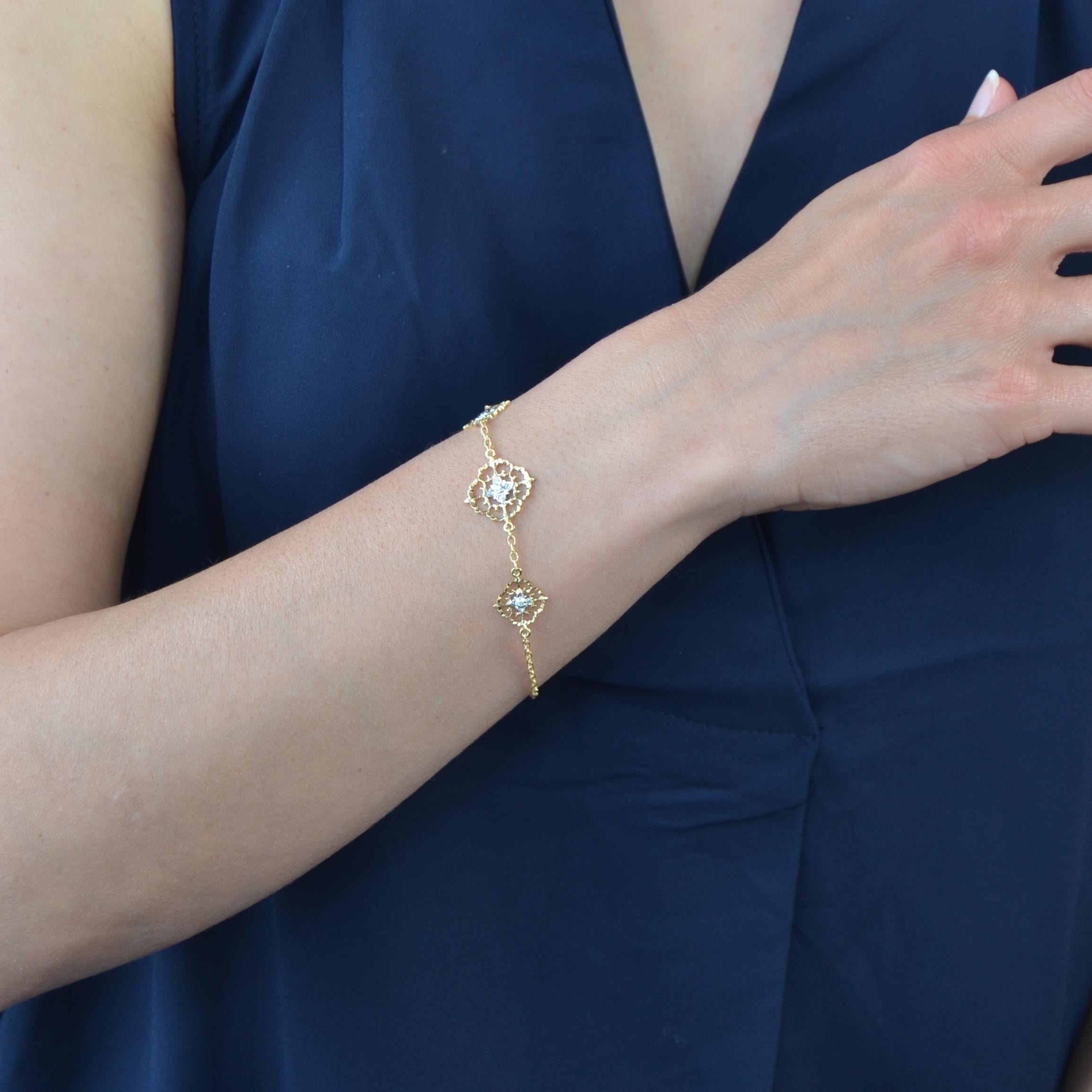 Bracelet en or jaune et blanc 18 carats.
Ce charmant bracelet en chaîne est décoré de 3 motifs plats percés, ciselés d'arabesques et sertis de diamants modernes taille brillant, celui du centre étant plus important. Ils sont séparés les uns des