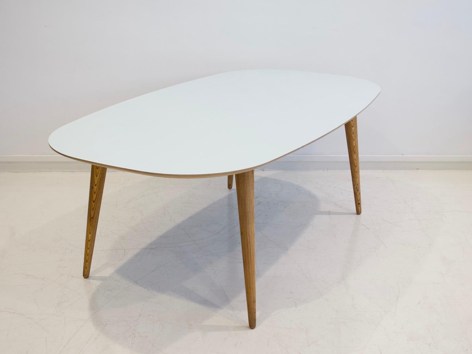 Dining table by master carpenter Lau Lauritsen, labeled under tabletop. Elliptical light blue color high-pressure laminate top, underside with black laminate. Conical oil-treated birch legs.