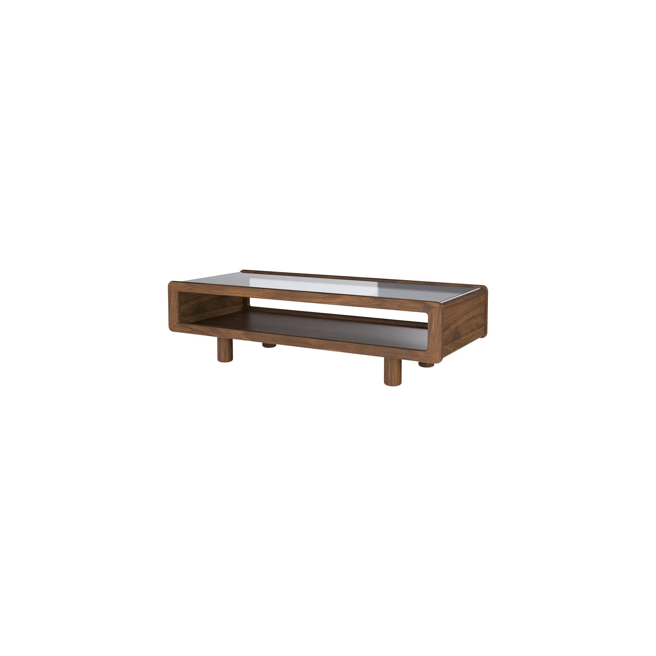 Our Modern Display Top Coffee Table's gentle organic silhouette features smooth, radiused edges, exuding an understated elegance that pays homage to iconic 1970s design. An inset glass top provides a striking showcase for your favorite books and