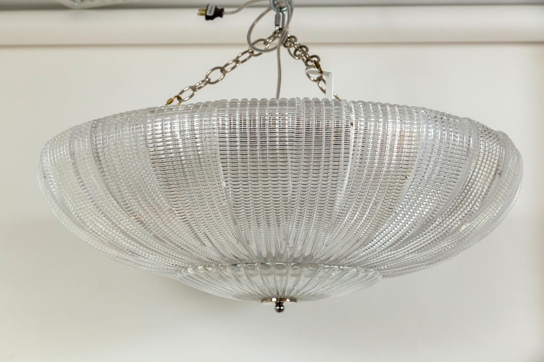 26 curved  waffle textured blown glass compose this sleek round near flushmount ceiling fixture finishing with a circuar plate and nickel polished finial.   Electrified to code with 6 medium base sockets for even illumination and a beautiful