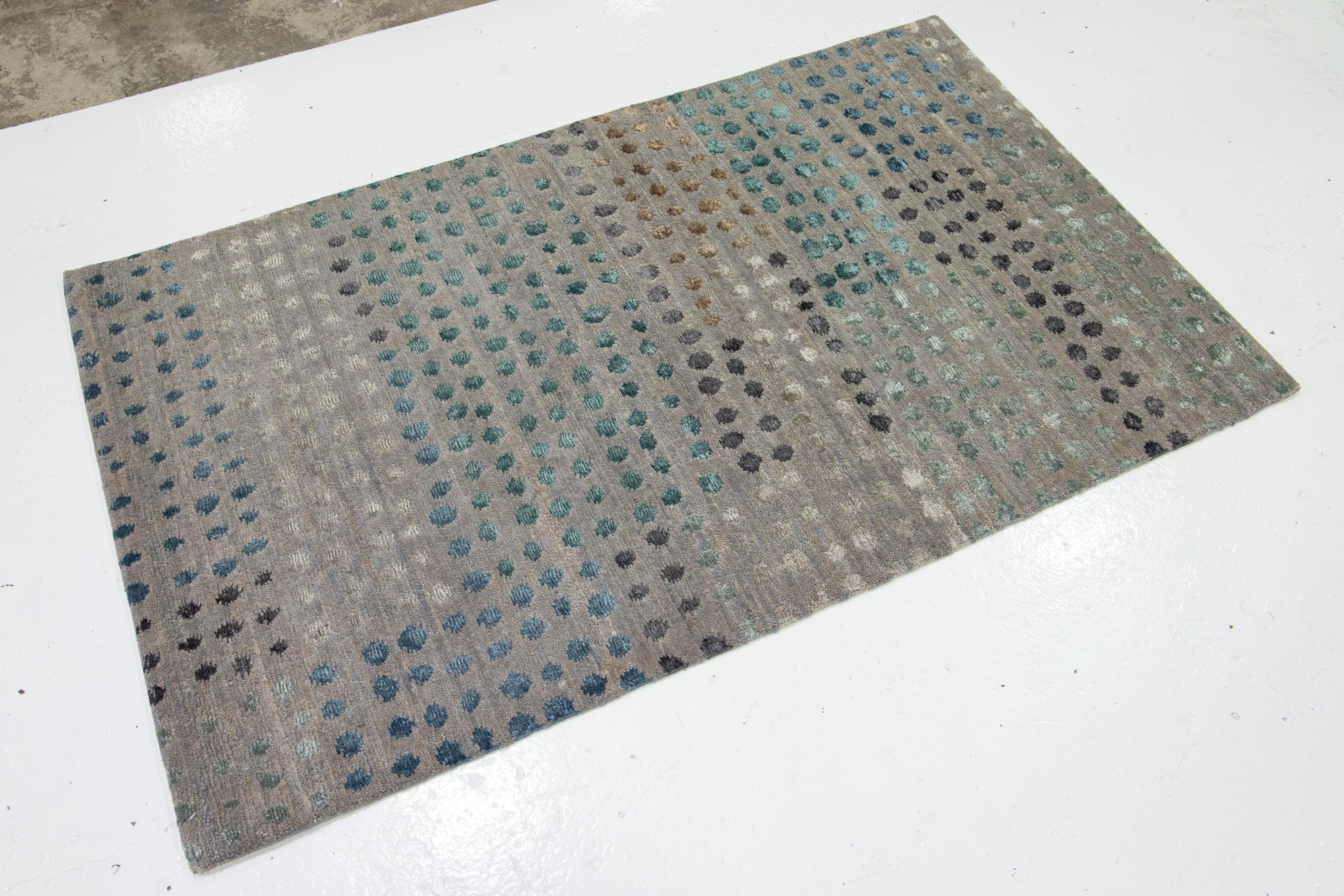 Questo moderno tappeto personalizzato presenta un'affascinante composizione di punti di seta, realizzati a mano in lana dell'Himalaya e seta di bambù. Scintillante e ricco su un campo grigio chiaro, conserva un'eleganza senza tempo.

Il prezzo si