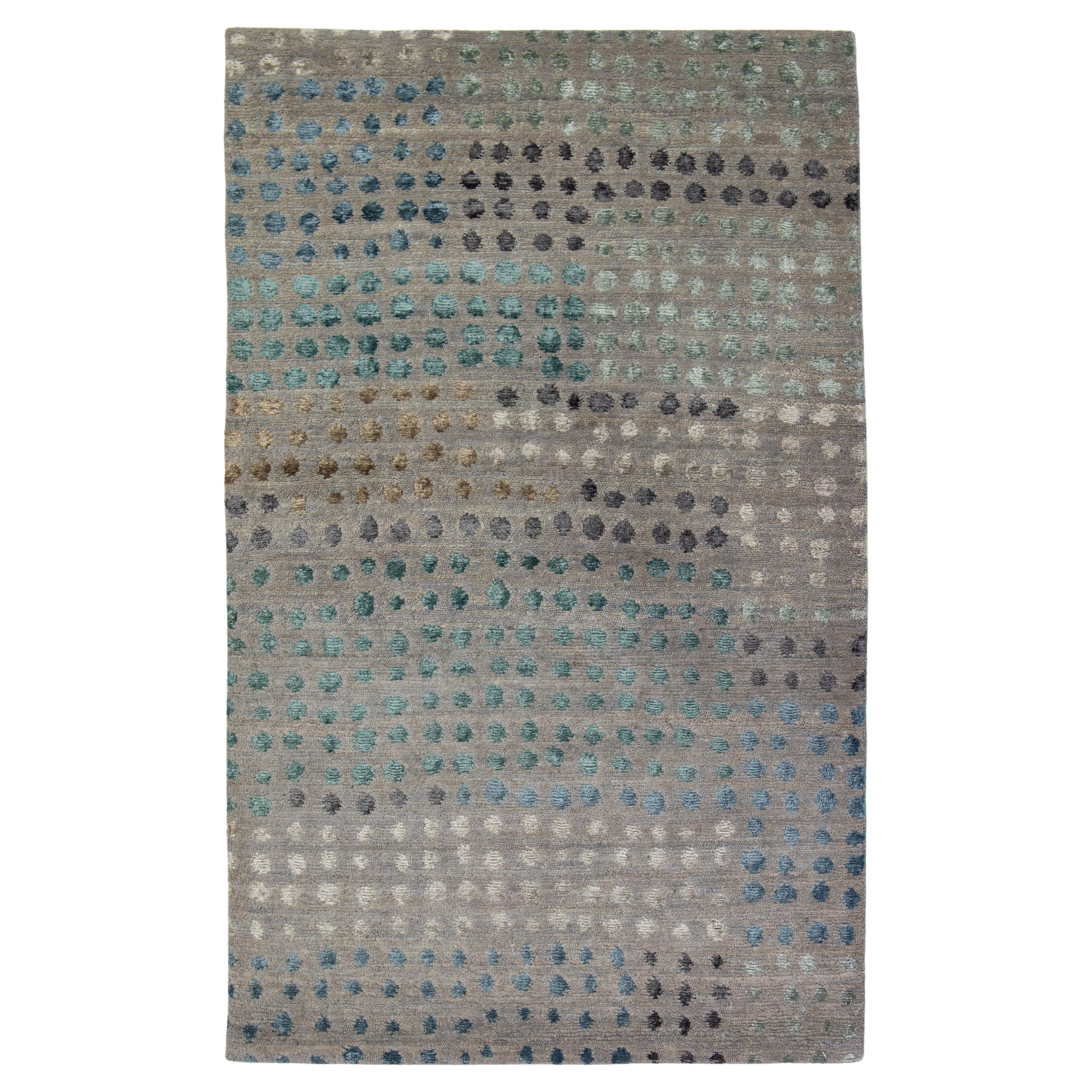 Tappeto moderno Dot Dot in lana e seta di bambù di colore grigio chiaro proveniente dal Nepal