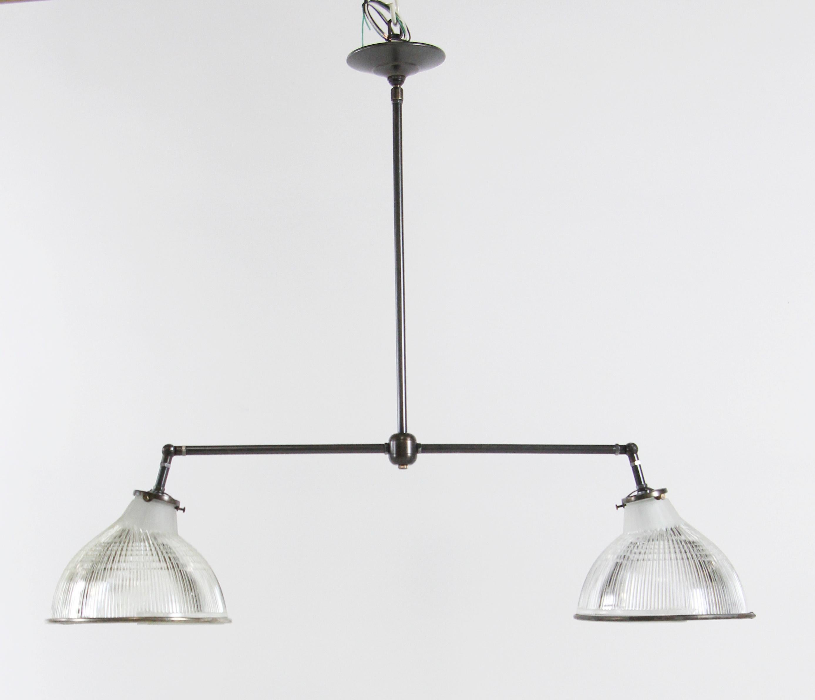 Modern bronze double light pendant with antique Holophane Industrial shades. The 'elbows' are adjustable so that the shades can be adjusted to any angle desired. Small quantity available at time of posting. Priced each.