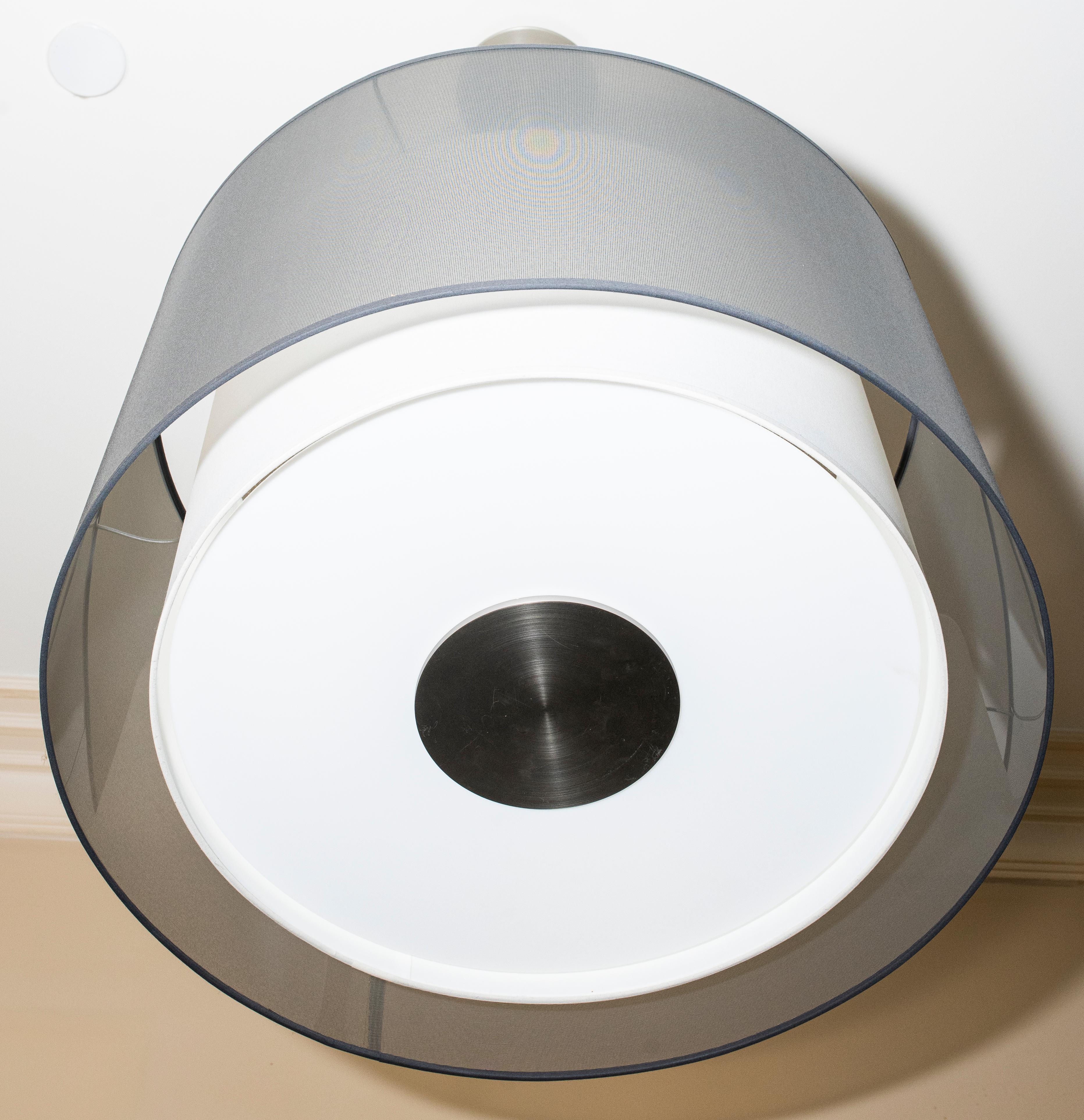 Luminaire suspendu moderne à abat-jour en gris avec des accents blancs sous l'abat-jour.