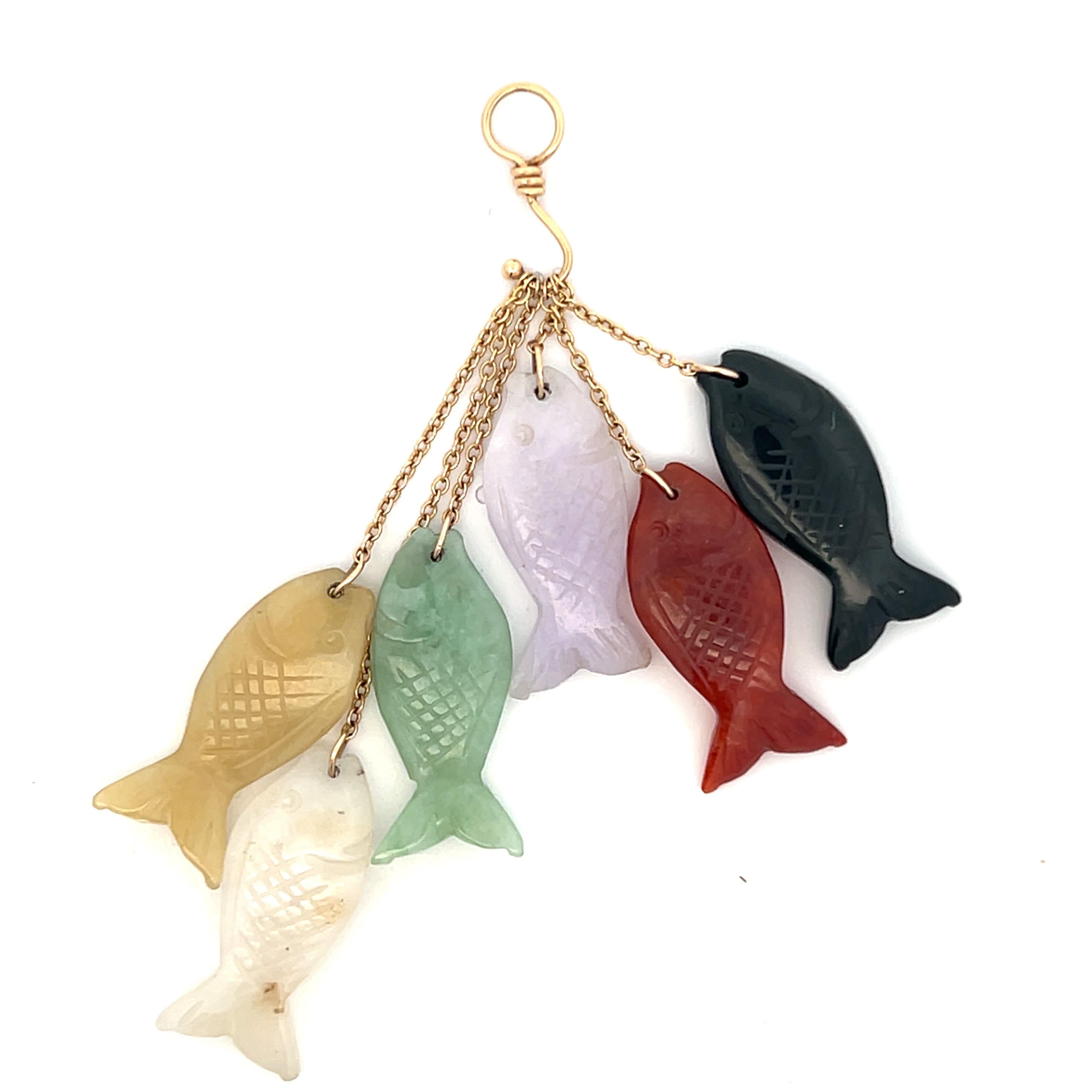 Make a splash with this delightful 1970s/80s 14-karat yellow gold and jade fish hook pendant! Dangling from the hook are six charming fish-shaped pieces of dyed jade, each carved with intricate detail in colors of creamy white, soft lavender, sunny