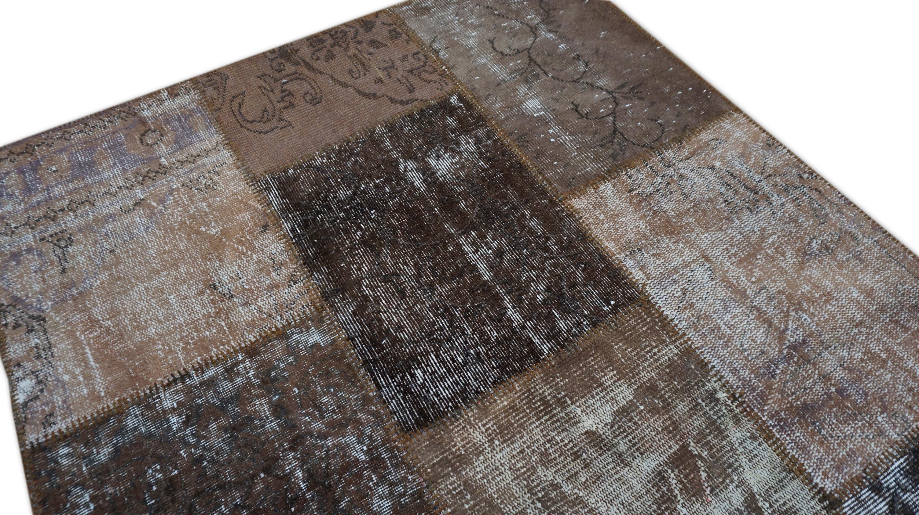 Esta alfombra de patchwork de lana tejida a mano es una sofisticada mezcla de artesanía tradicional y arte moderno. Construida a partir de fragmentos de alfombras vintage recuperadas -cada una teñida y ensamblada a mano-, esta pieza muestra una