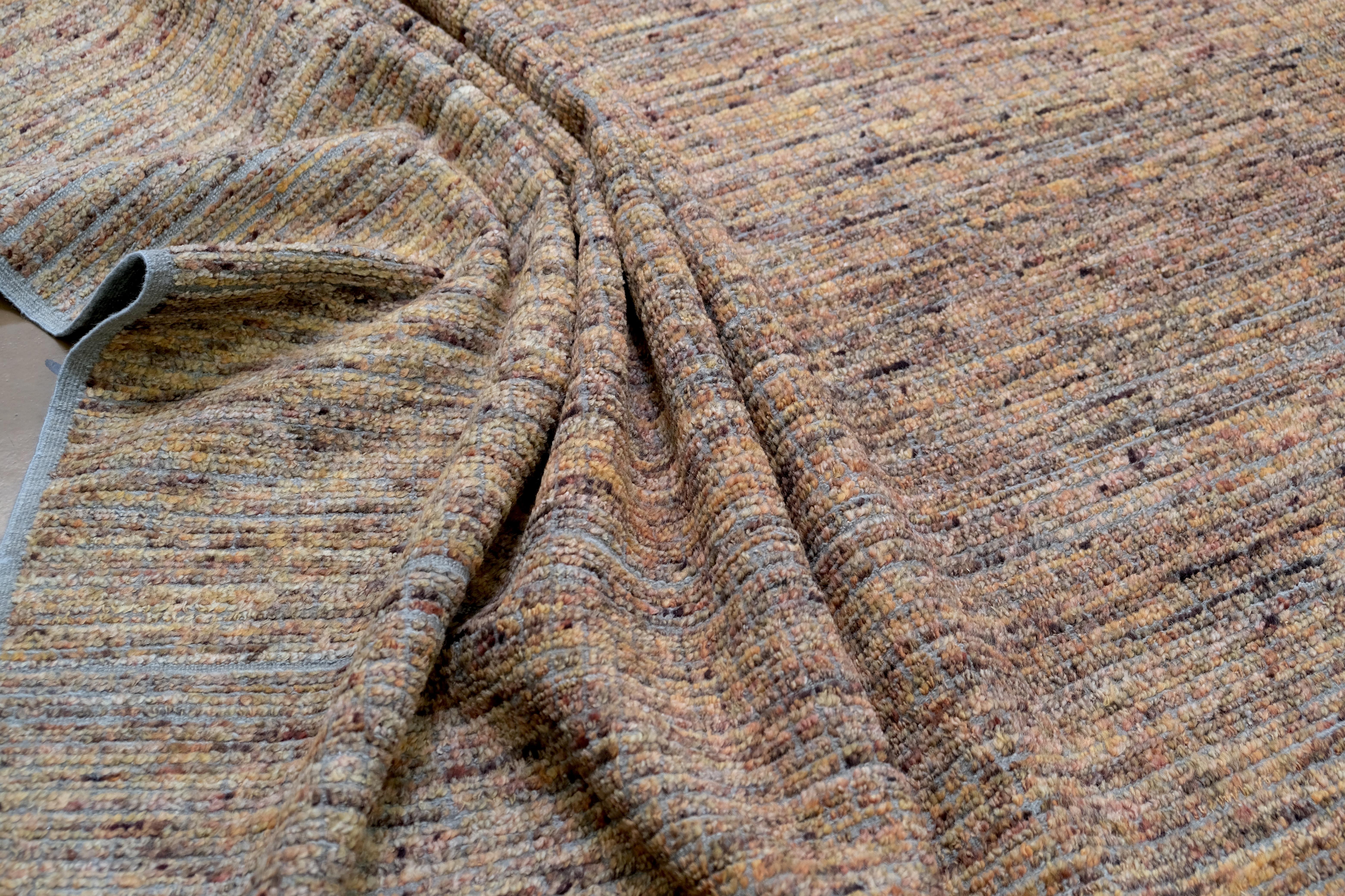 Ce tapis exquis en laine nouée à la main est un chef-d'œuvre d'élégance discrète et de texture organique. Entièrement tissée à la main selon des techniques séculaires, cette pièce présente un subtil motif dégradé qui se déplace sur la surface dans