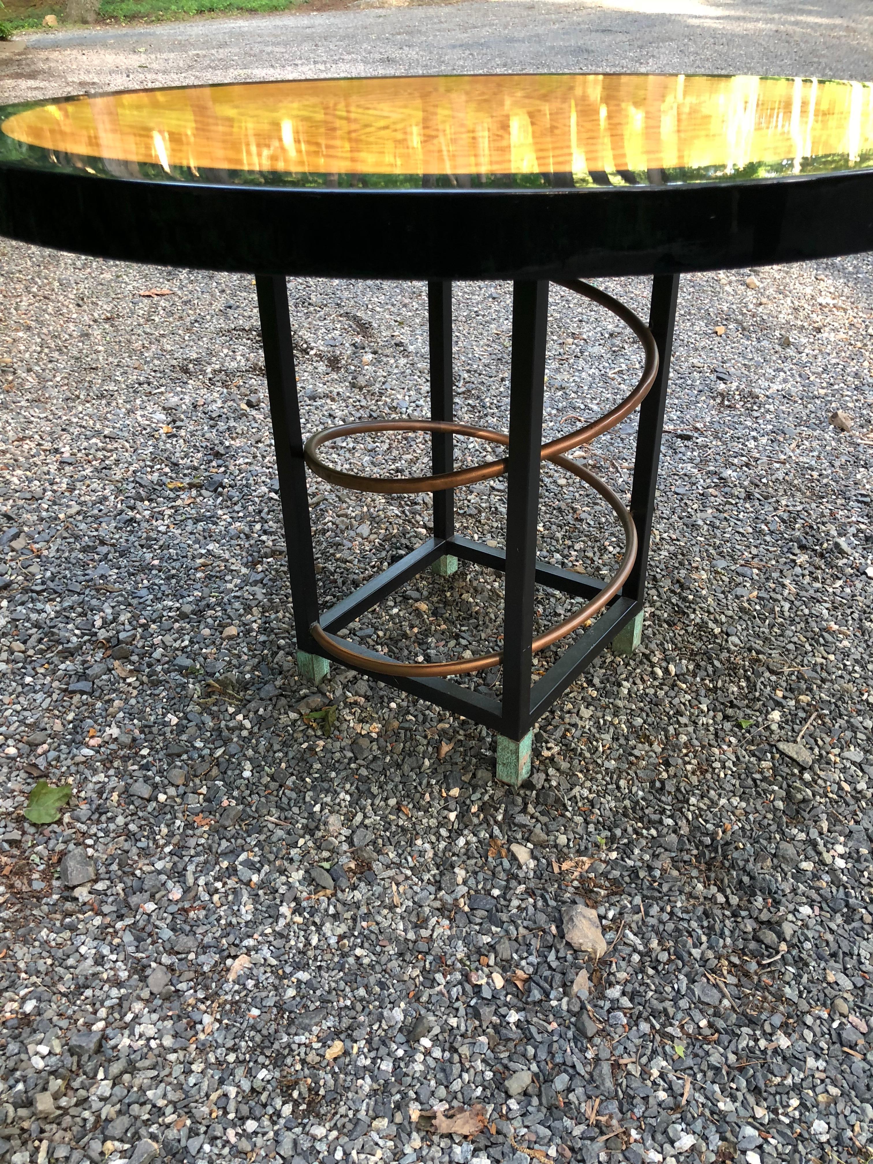 Very cool partially ebonized wood lacquered dining or breakfast room table. The base of the table is constructed of steel with brass decoration and verdigris feet. Apron is 2 inches.