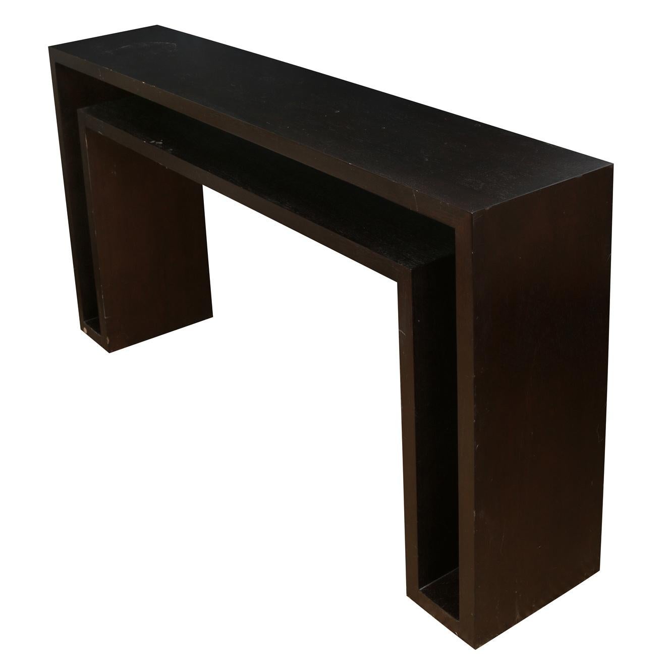 A modern ebonized cerused oak console table with open angular design.