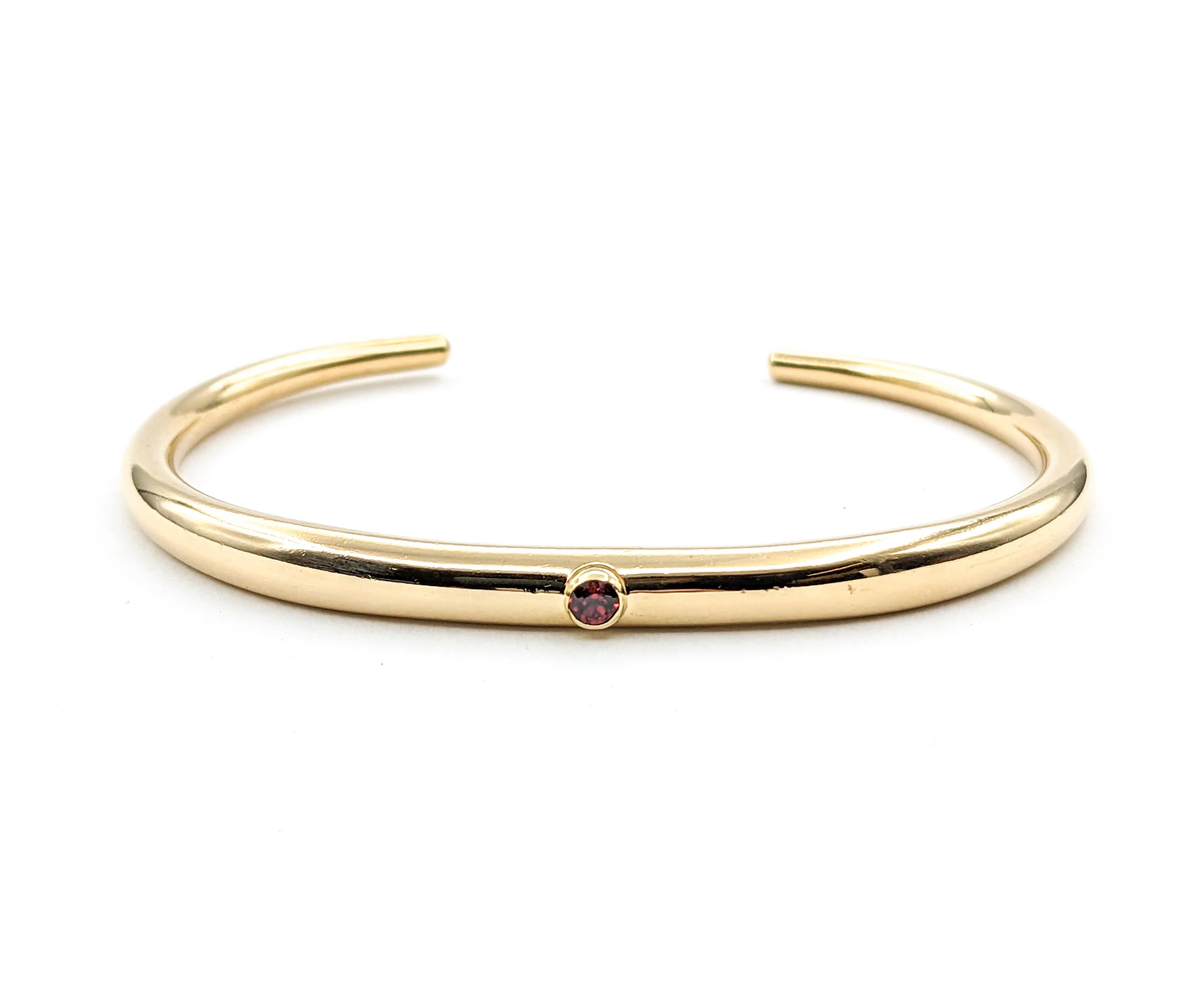 Modern Ed Levin Garnet Cuff Bracelet in Yellow Gold

Experience timeless beauty with our vintage Ed Levin cuff bracelet, expertly fashioned in 14-karat yellow gold. At the center of this exquisite piece is a bezel set .14ct round garnet, sparkling