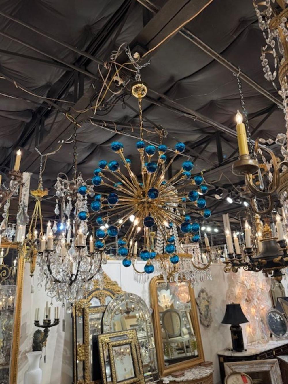 Stunning modern electric blue Murano glass and brass chandelier. Crafted for those who appreciate contemporary elegance, this Electric Blue Murano Glass and Brass Sputnik Chandelier is a striking addition to any interior space. A real conversation