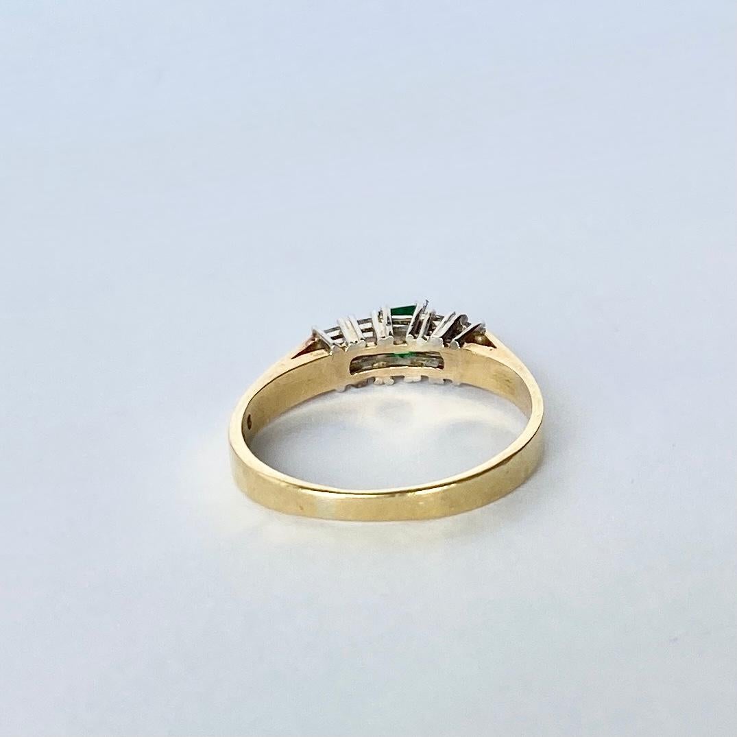 An exquisite five-stone ring set with beautiful princess cut diamonds and a step cut emerald. The central emerald measures 15pts and the diamond total is 40pts. 

Ring Size: N or 6 3/4
Widest Point: 4mm
Height Off Finger: 5mm

Weight: 2.8g

