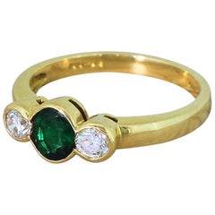 Modern Emerald and Round Brilliant Cut Diamond Trilogy Ring