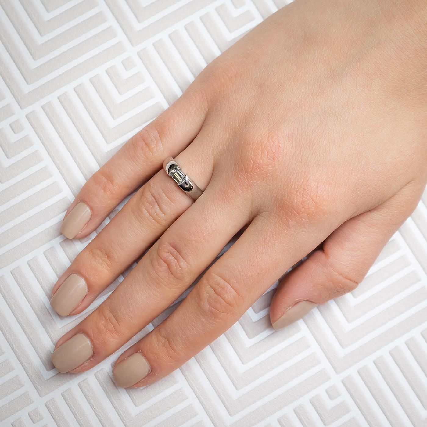 Un anello con diamante, con un diamante taglio smeraldo da 0,54 ct, colore D, purezza VVS2, incastonato orizzontalmente, montato in platino.

Misura delle dita UK L ½ / US 6.