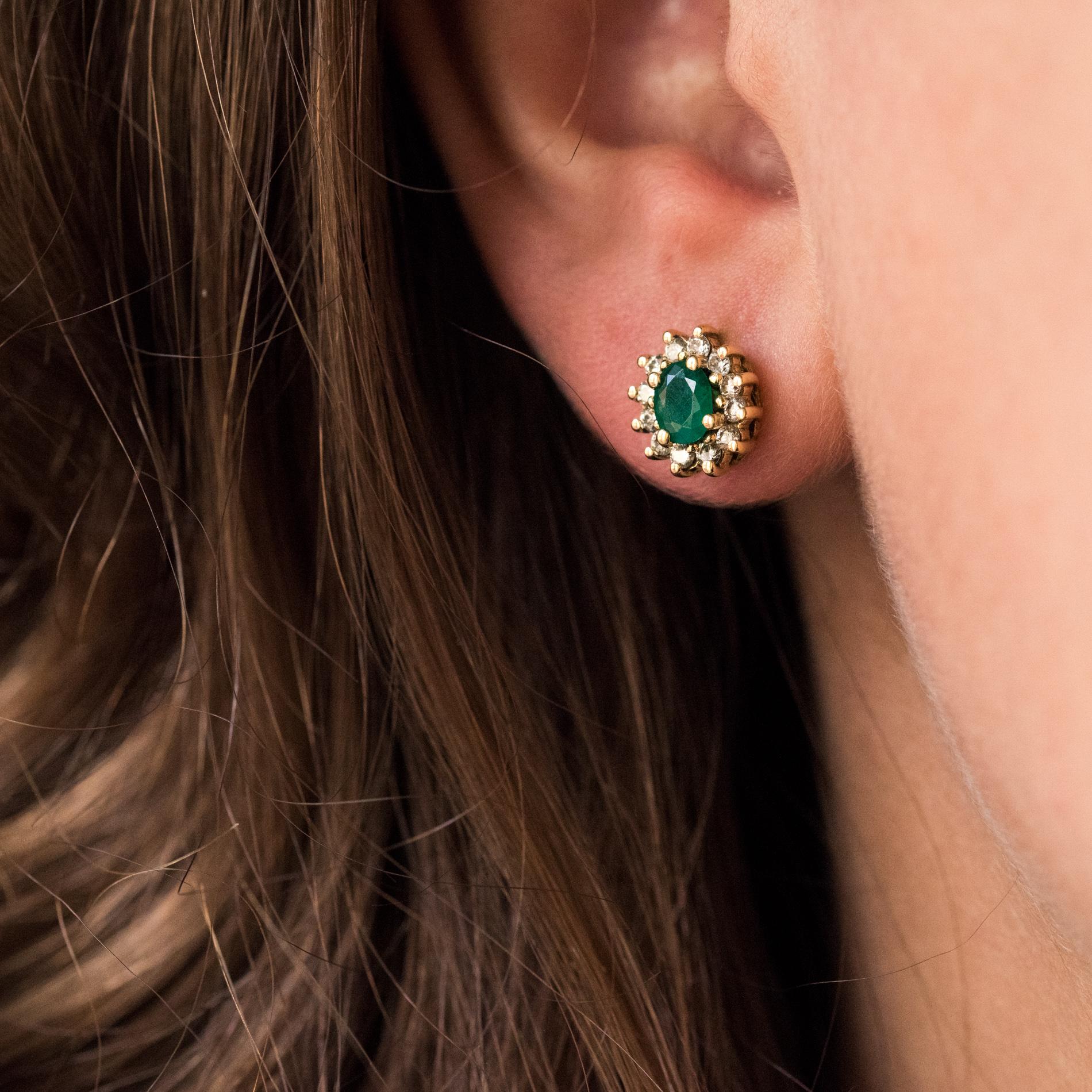 For pierced ears.
Earring in 18 karats yellow gold.
Lovely yellow gold earrings, each is set on a daisy pattern of an oval emerald, surrounded by brilliant-cut diamonds. The clasp is an Alpa system.
Height: 9.6 mm, width: 8.6 mm, thickness: 4.5