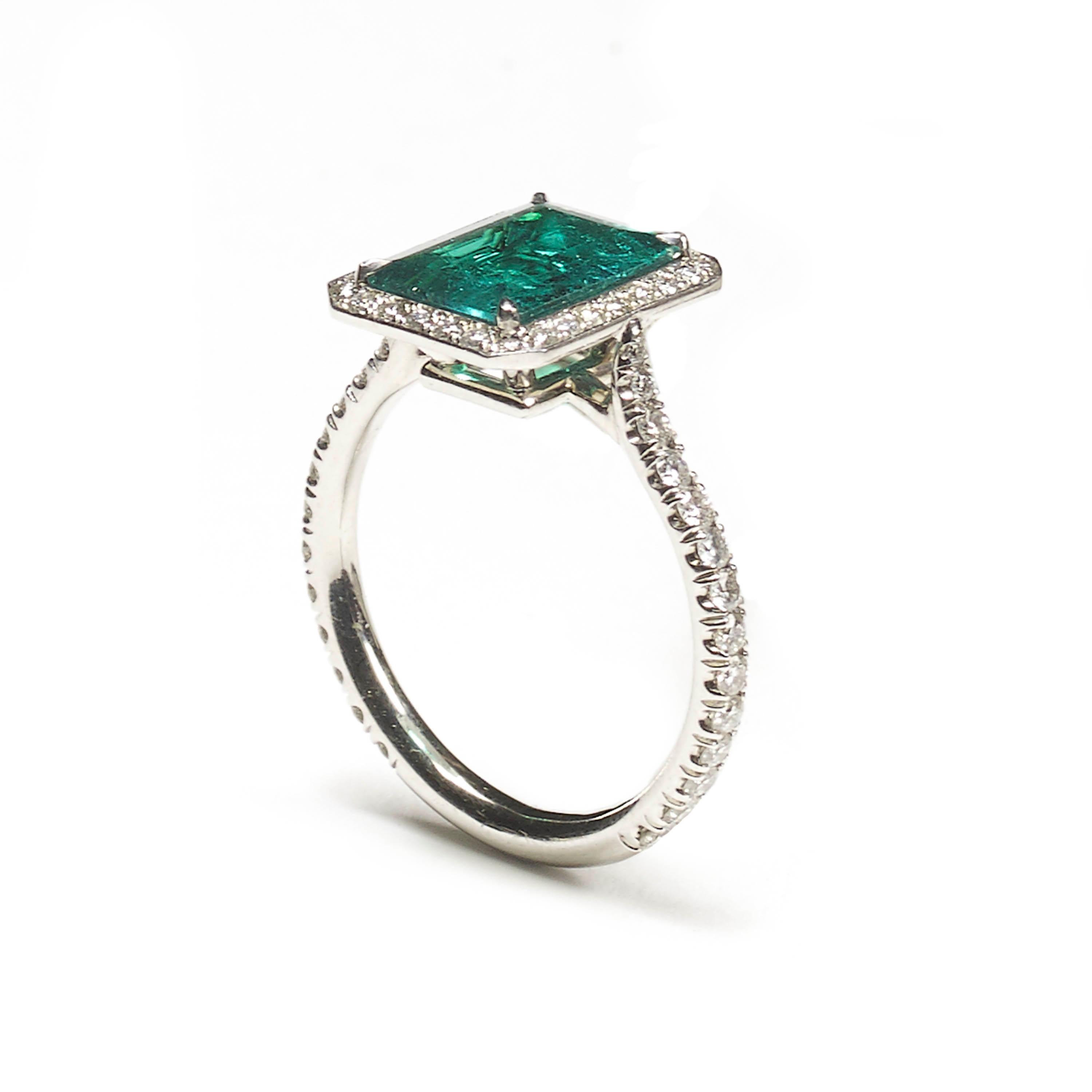 A modern emerald and diamond ring, set with an emerald-cut emerald, weighing approximately 2.03ct, in a four claw setting, with a micro pavé set surround and shoulders, mounted in 18ct white gold.
Finger size L UK / 5½ USA