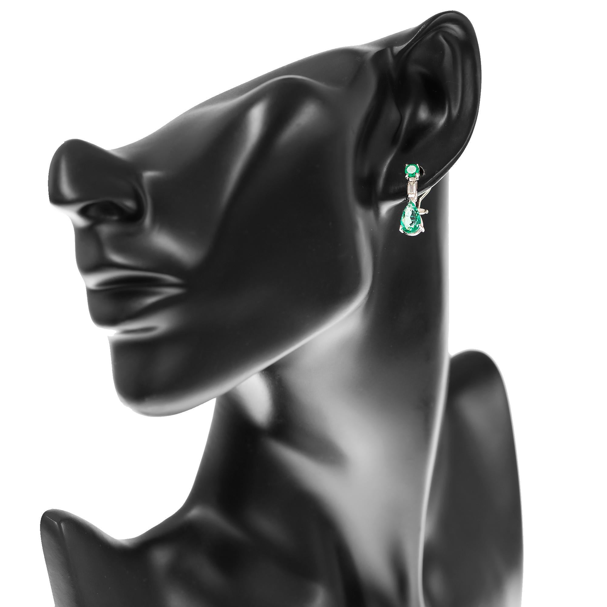 Crafted in platinum, this pair of earrings features pear and round cut natural bright green emeralds with baguette cut diamonds.
With a stud like fitting appearance the earrings sit firm on the ear with a drop just below the earlobe.
Fitted with a