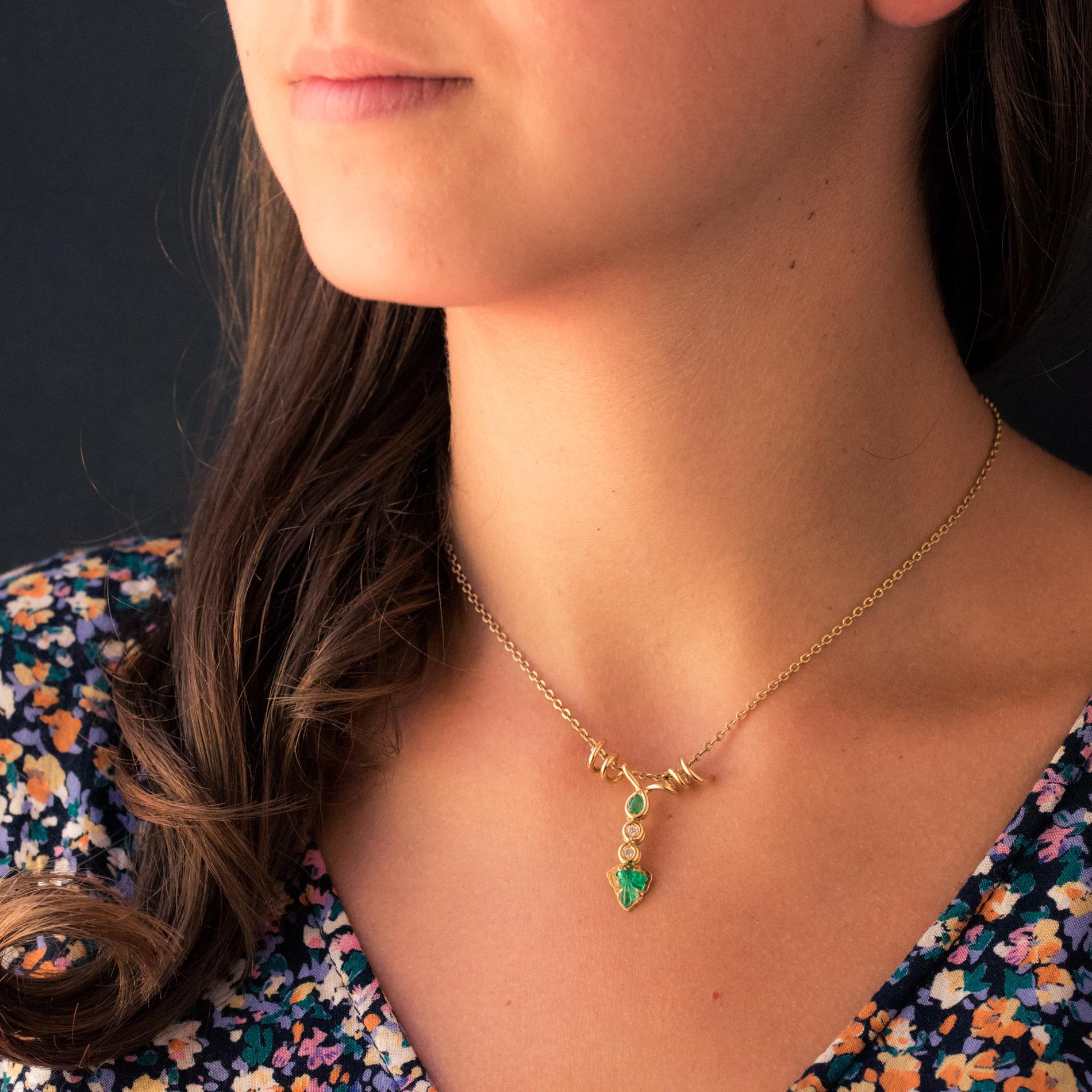 Pendant in 18 karat yellow gold.
This gold pendant is intended for a lover of the vineyard. It represents a coiled vine stock set on the front with a bezel-set motif with a pear-cut emerald, 2 modern brilliant-cut diamonds, and a flat gold motif