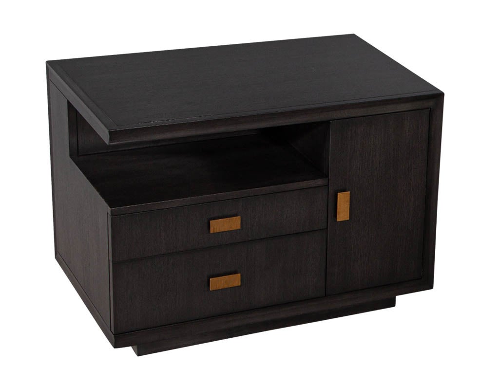Modern end table in grey charcoal finish and bronzed hardware. Finished in a charcoal grey stain and adorned with bronzed hardware. Featuring ample storage with 2 drawers, 1 door with large compartment and open shelf. A great additional to any