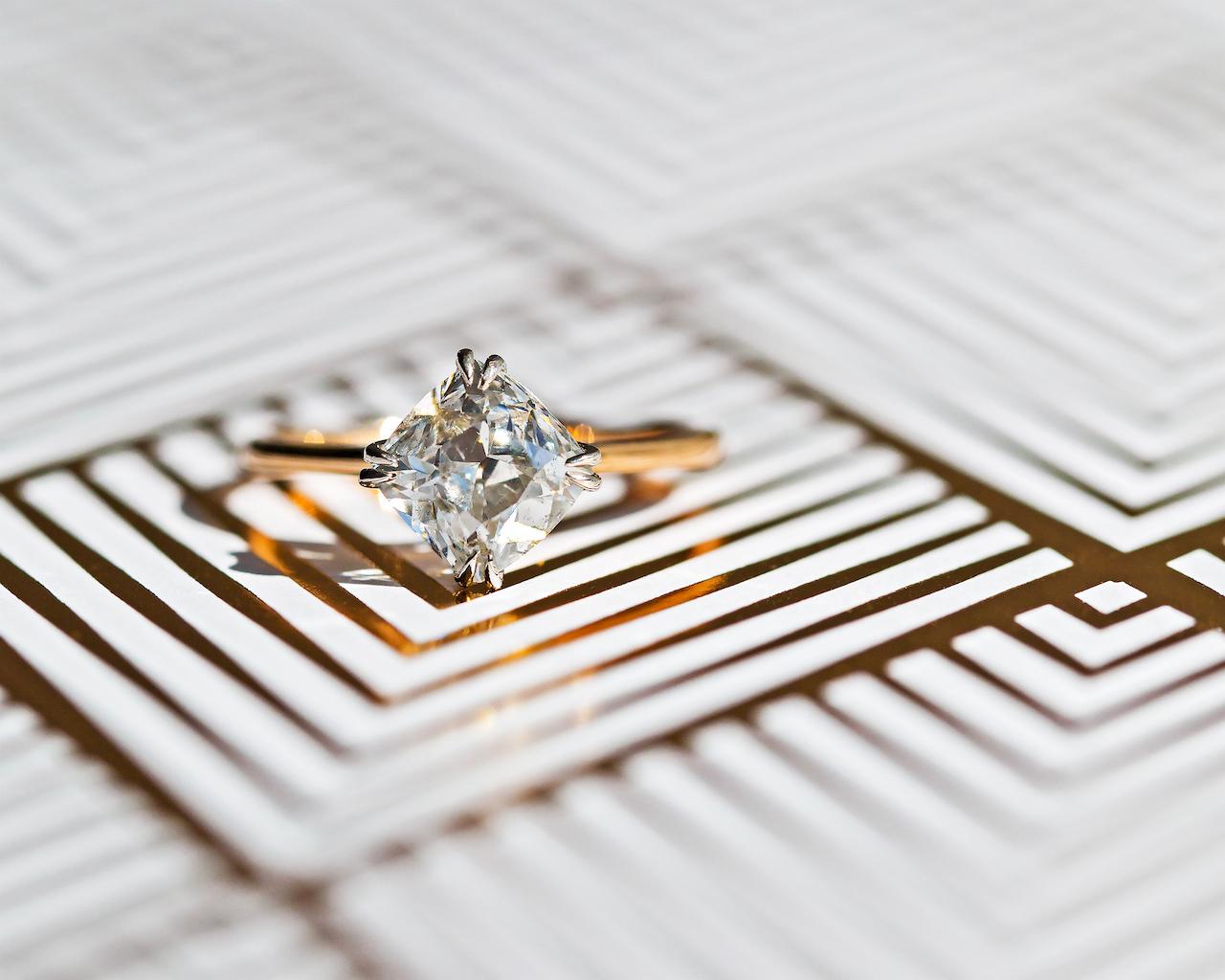This is a wonderfully unique and newly-made solitaire engagement ring crafted locally in downtown Los Angeles. The platinum and 18k rose gold ring centers an antique diamond nestled between talon prongs off-set diagonally. The gorgeous stone is