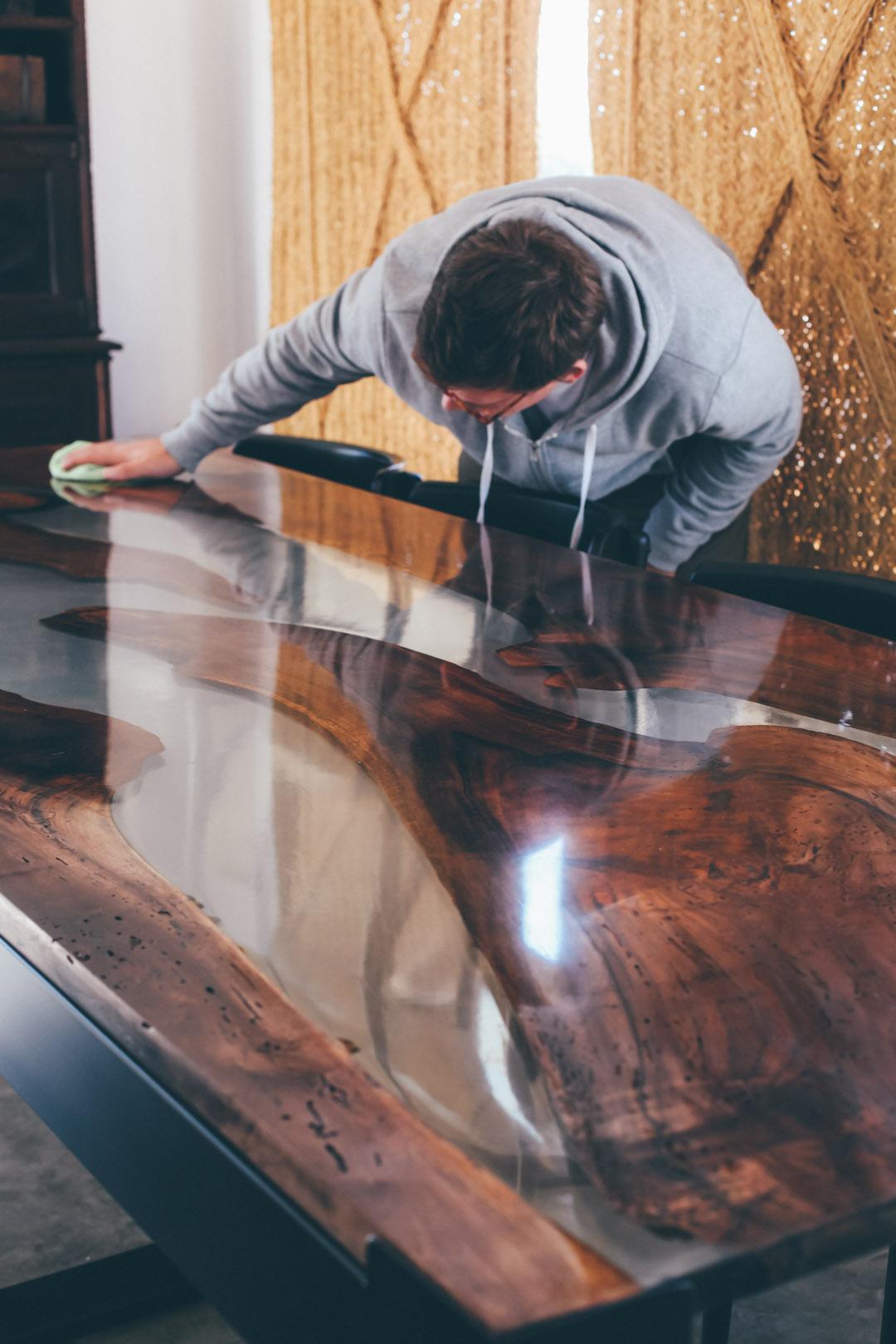Wunderschöne Verbindung zwischen der wahren Natur und Form der Nussbaumplatten mit dem festen und transparenten Epoxidharz.
Geschwärzte Eisenbeine, die dem Tisch Struktur verleihen und die Farben und Formen der Tischplatte hervorheben. 
Dieser