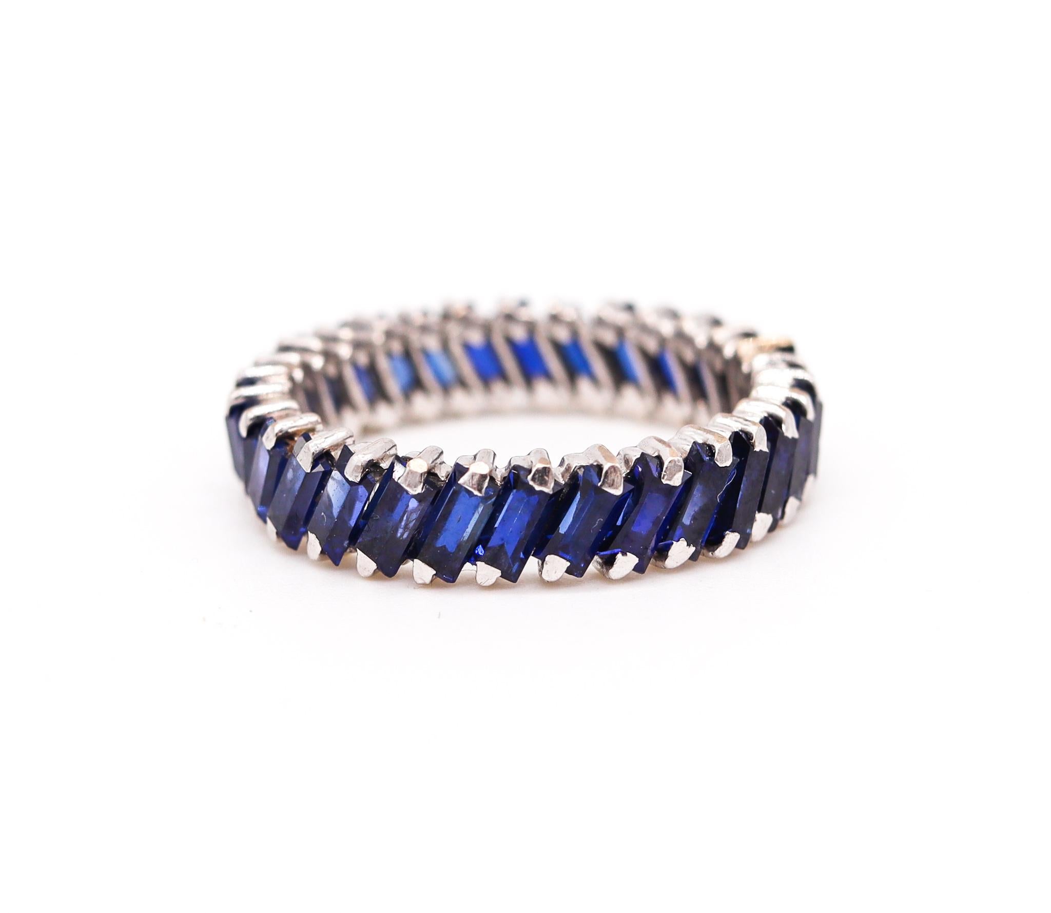 Custom made eternity ring with blue sapphires.

A rare full eternity ring crafted with textured sides in solid .950,999 platinum. It is continuously mounted diagonally in single point prong settings with 30 straight baguettes cut from natural blue