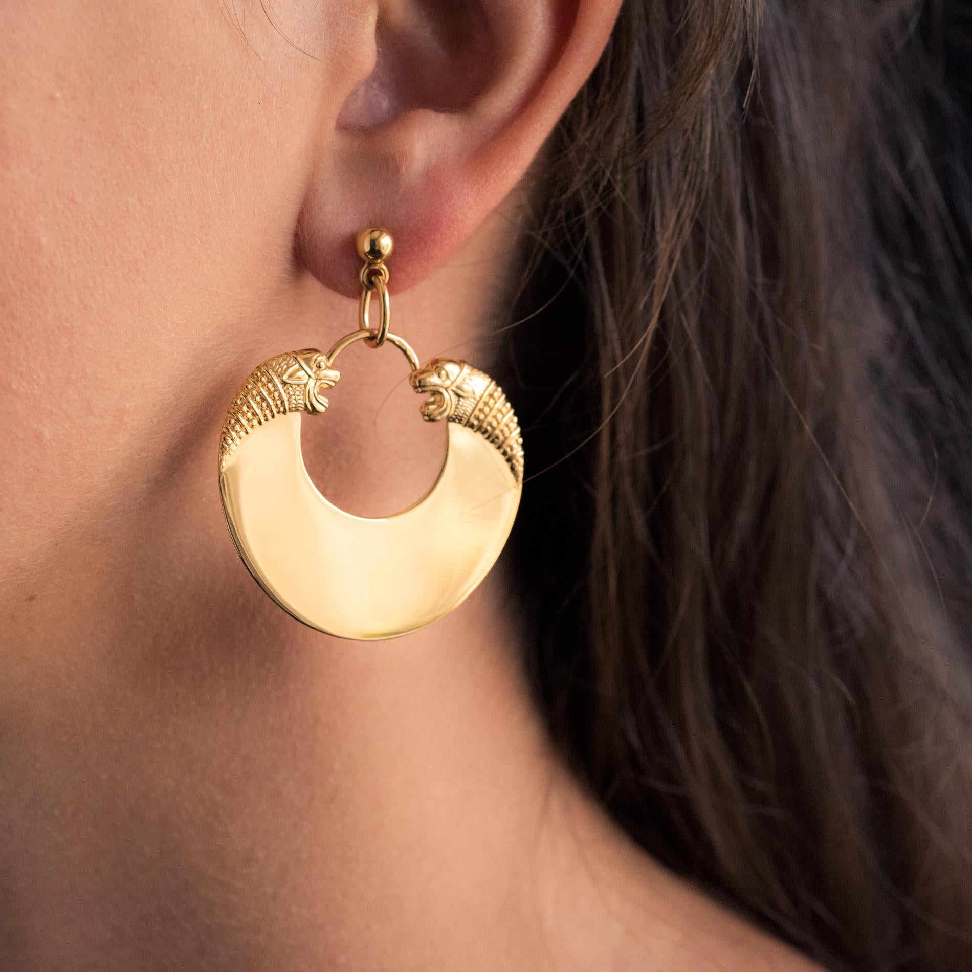 For pierced ears.
Earring in vermeil, silver and yellow gold.
Dangling earrings, they form a half moon adorned at each end with a profile of fantastic animals with a chiseled pattern. They are held by a gold pearl. The hanging system is a