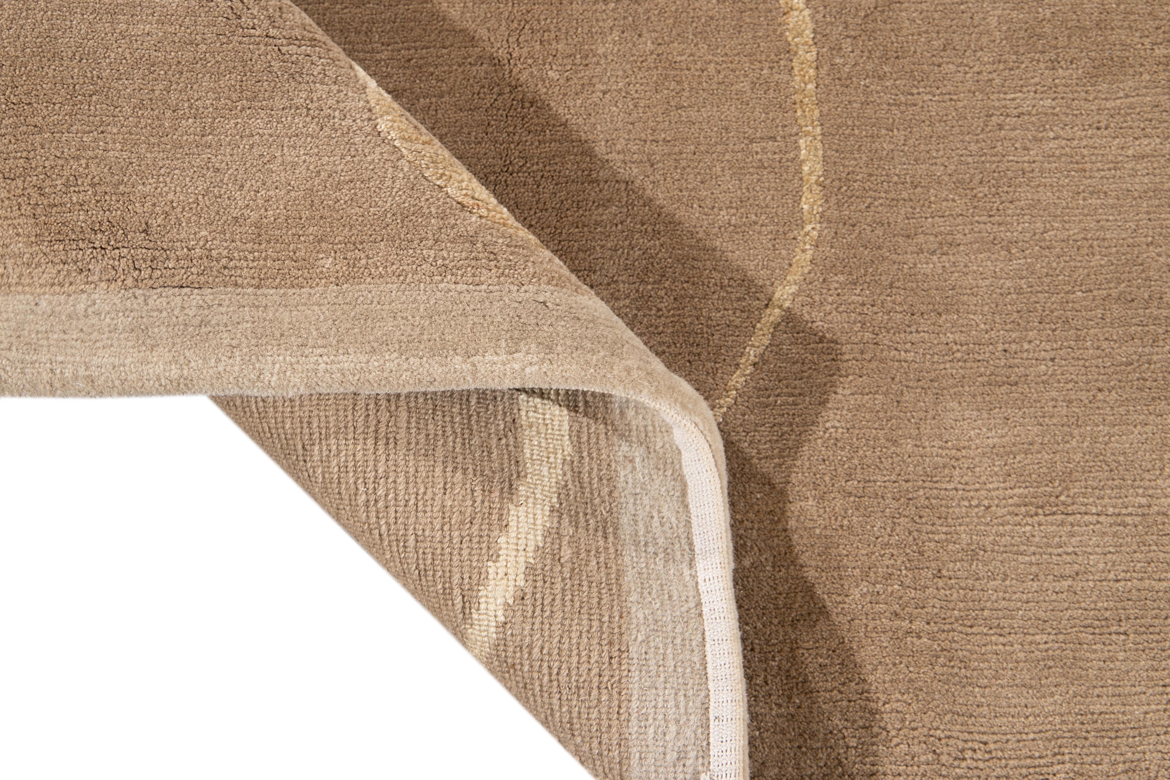 Beautiful modern Tibetan hand knotted wool rug with the tan field. This rug has accents of beige in a gorgeous all-over abstract expressionist design.

This rug measures: 9' x 12'.