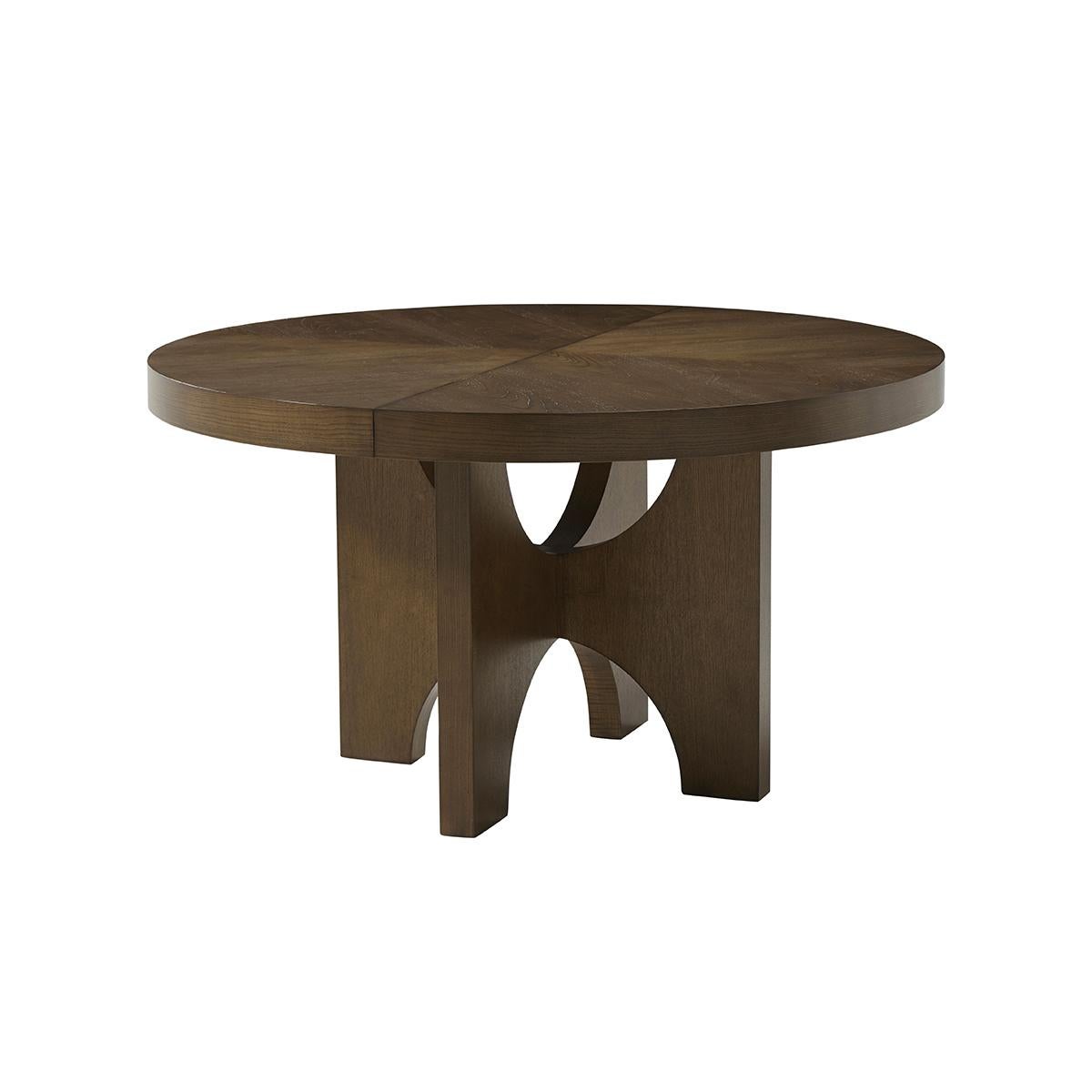 Modern Extending Ash Dining Table, crafted from premium-figured cathedral ash, this dining table boasts a rich texture and a sleek, dark finish that adds a touch of elegance to any dining room. The closed round shape of the table invites an intimate