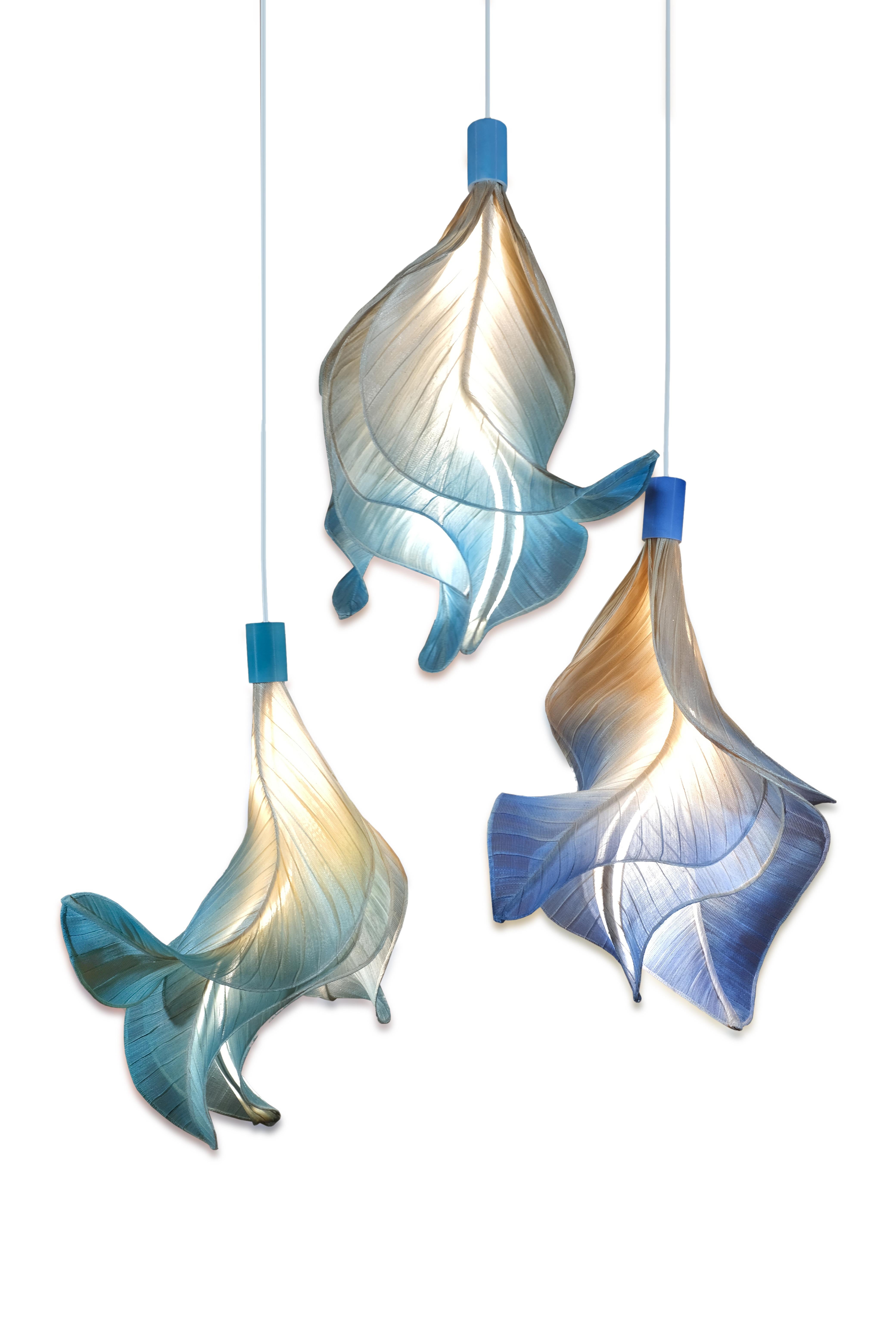 Sirenetta; inspired by a sea siren. 

When the sun hits the horizon, imagine it gracefully swimming to the water surface to catch a glimpse of her lover. This suspension lamp is made from banaca (banana-abaca) textile, sculpted to evoke undulating