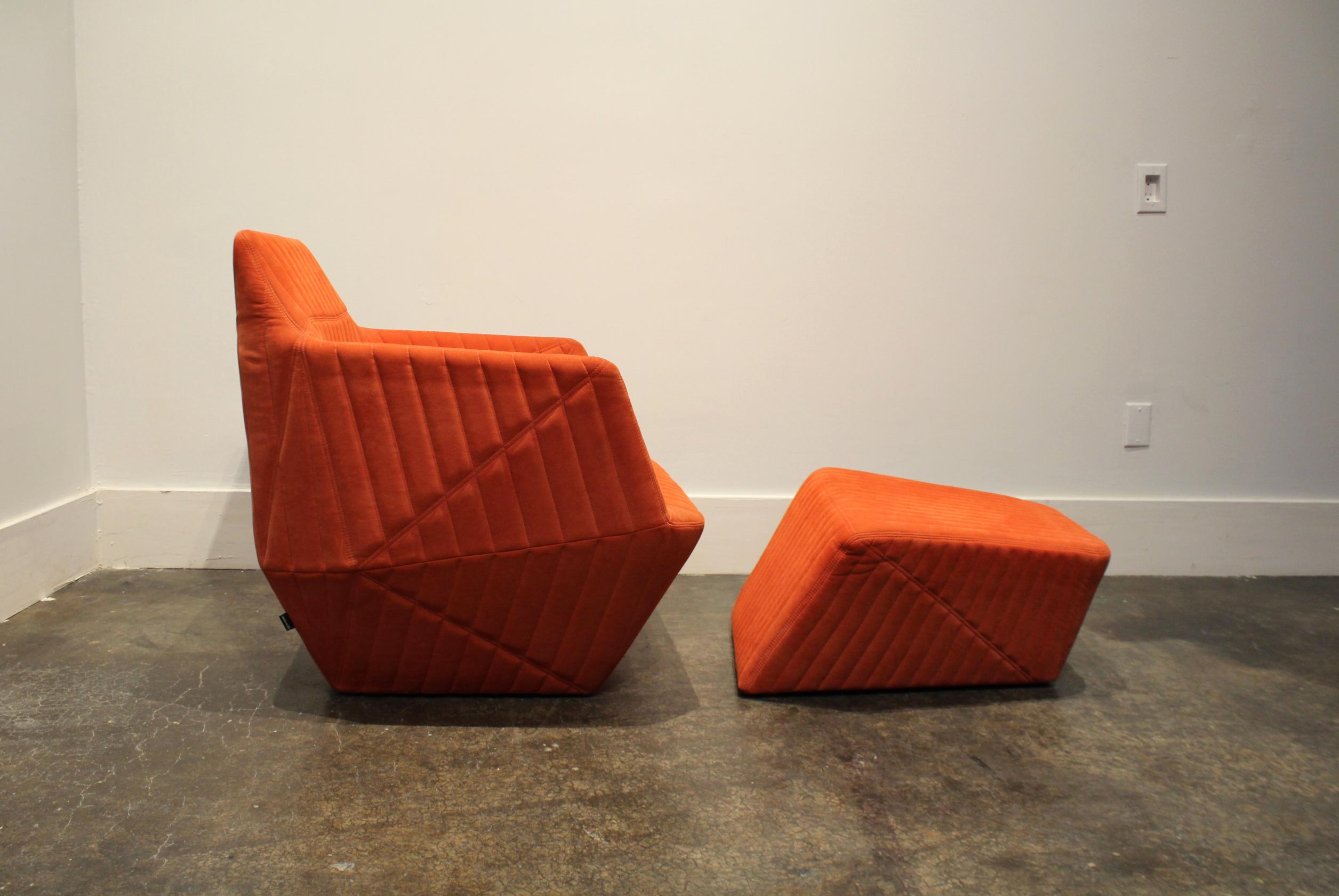Modern Facett lounge chair and ottoman by R. & E. Bouroullec for Ligne Roset in rare tangerine/orange color. The extensive stitching across all surfaces of this piece gives it a monolithic, and very contemporary, sculpted look. Construction; three