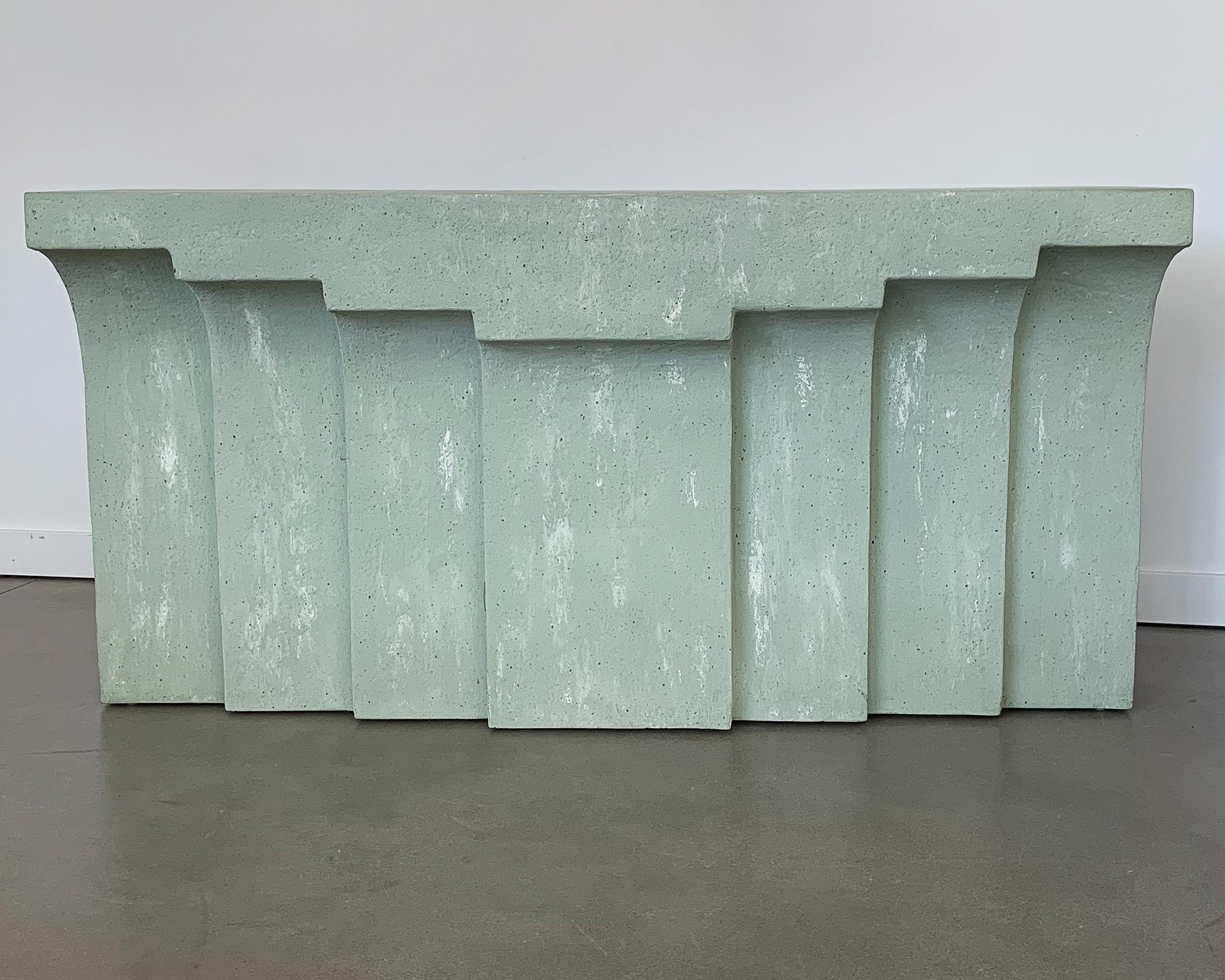 Unique modernist faux concrete or plaster console table in a pale sea foam green color. Fiberglass construction with textured surface to resemble cast concrete or plaster. Stepped modern arched design. Finished on all sides and washed with white to