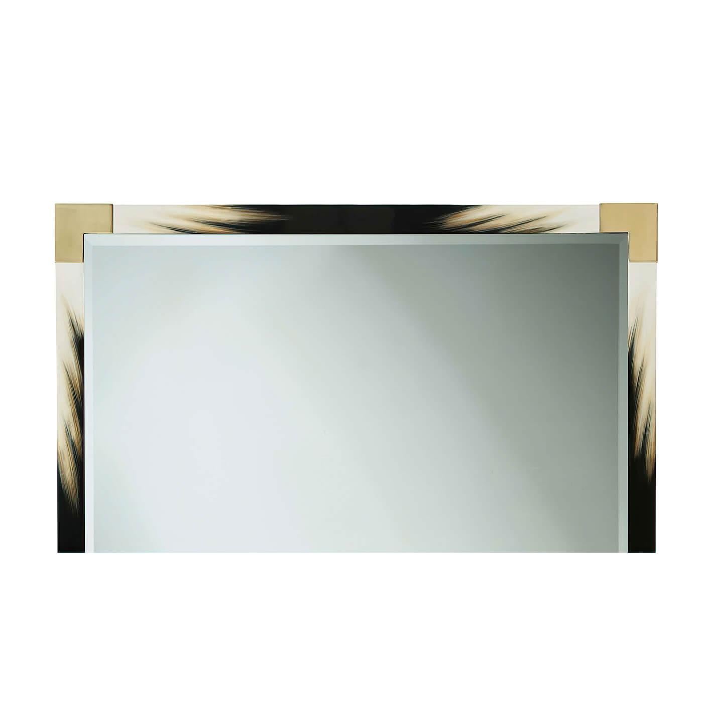 A large modern black lacquered and faux horn mirror, the rectangular top with brass edged corners, enclosing a bevelled edge plate.
Dimensions: 38