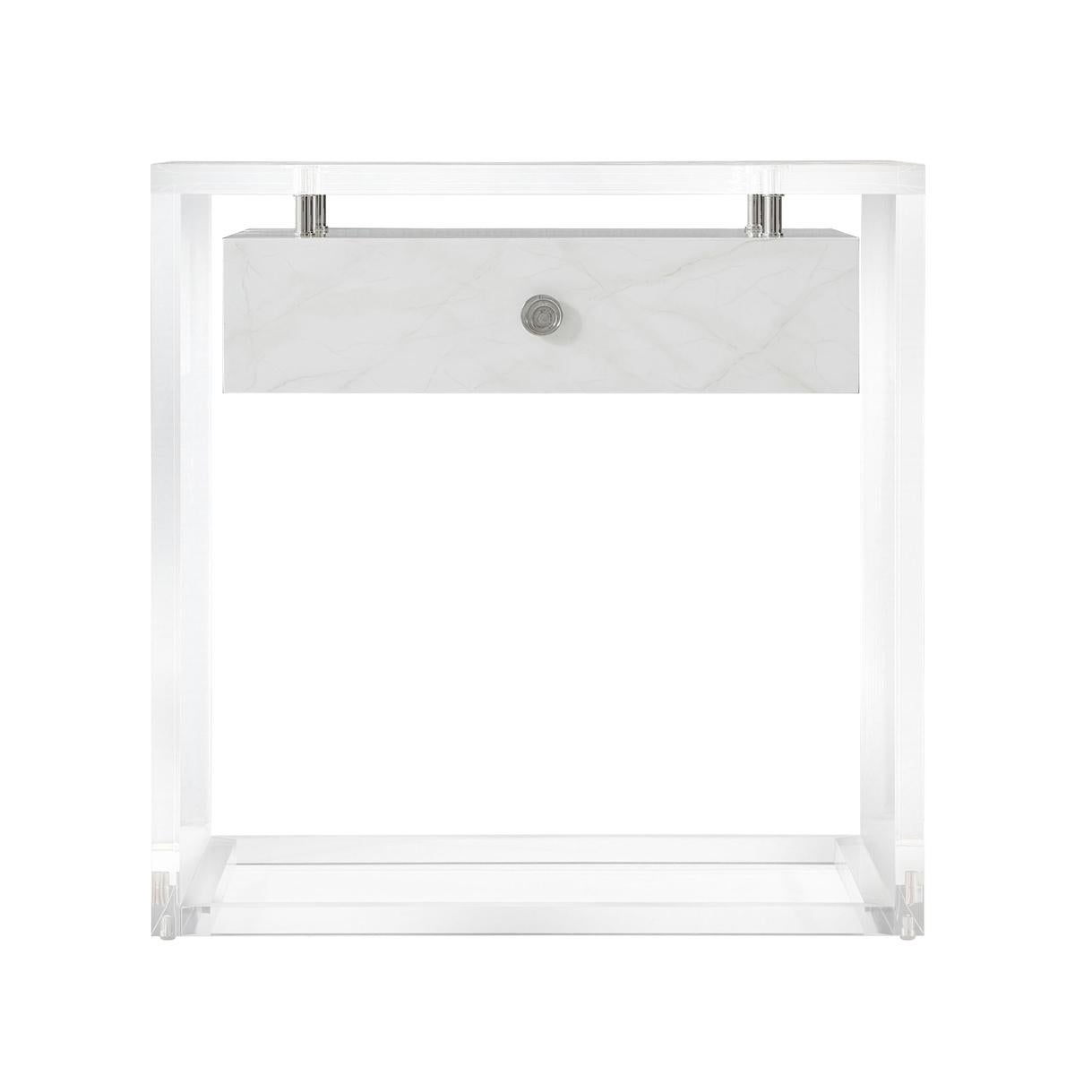 With solid acrylic top and sides and a framed acrylic base, with stainless steel exposed hardware and a suspended faux Carrara marble lacquered soft closing drawer.
Dimensions: 26