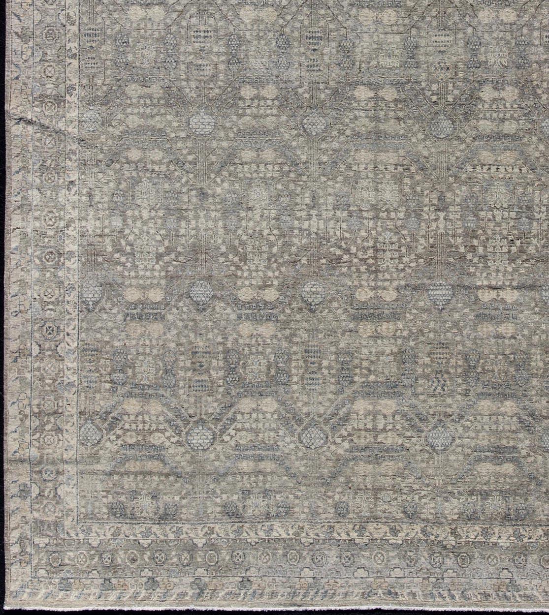 Taupe, gray, blue and neutral tones geometric Herati Tabriz design rug. Keivan Woven Arts / rug PMZ-85034856, country of origin / India type: Tabriz.
Measures: 9'11 x 13'9.
This Tabriz carpet features a field filled with an all-over design