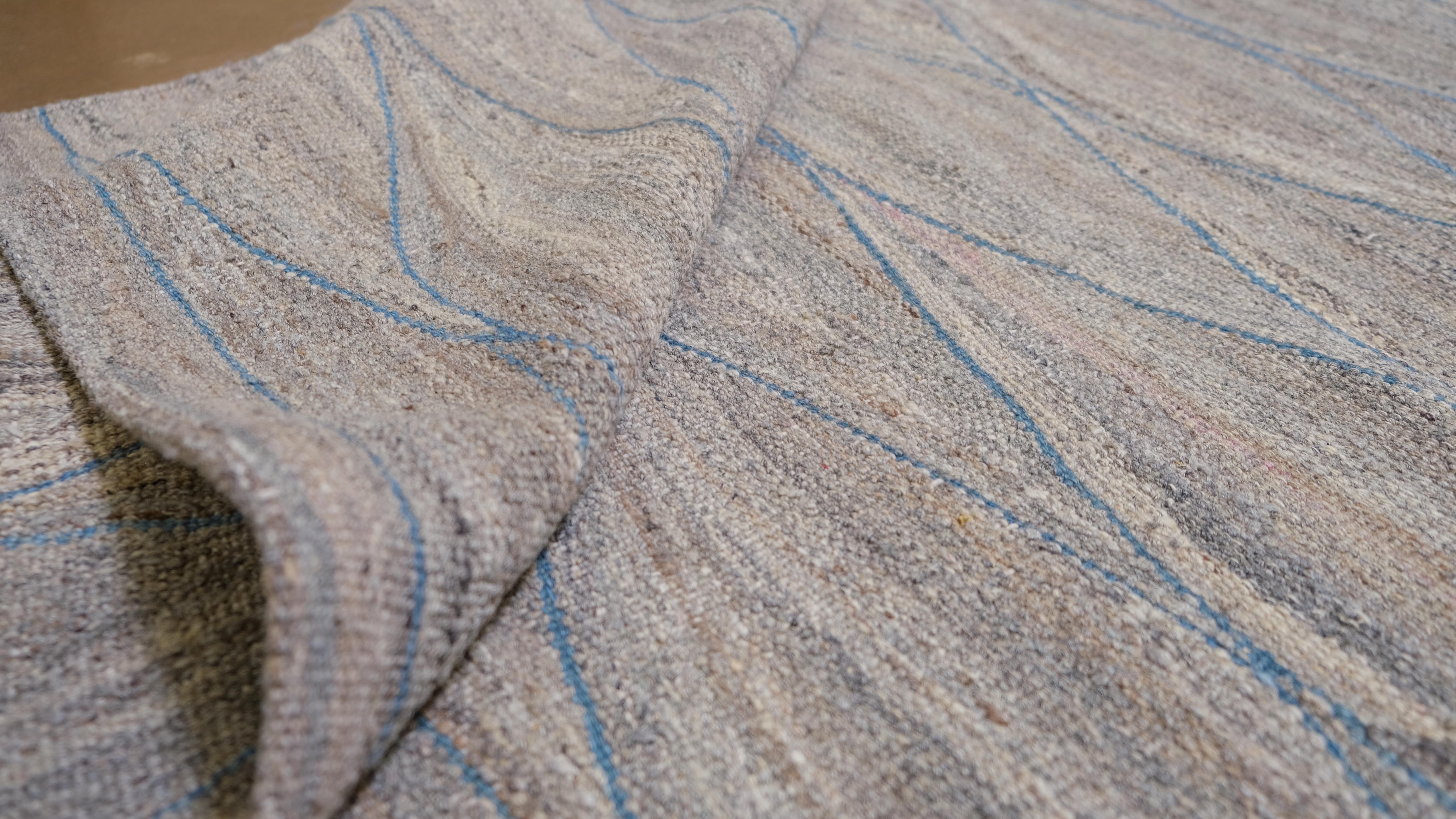 Immergez votre intérieur dans la beauté raffinée de ce tapis kilim woo tissé à la main, conçu pour imiter le flux gracieux des vagues de l'océan. Mesurant 11'10