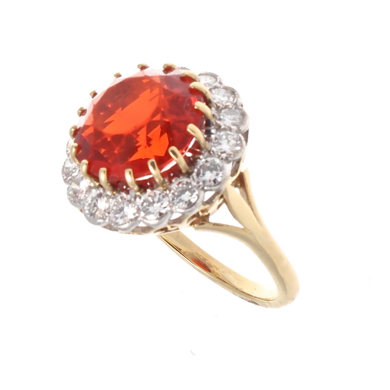 Fire Opal is a variety of opal that has a bright yellow, bright orange or bright red background color. Featuring an approximately 4 carat scorching reddish-orange fire opal surrounded by a halo of colorless round brilliant cut diamonds. Crafted in