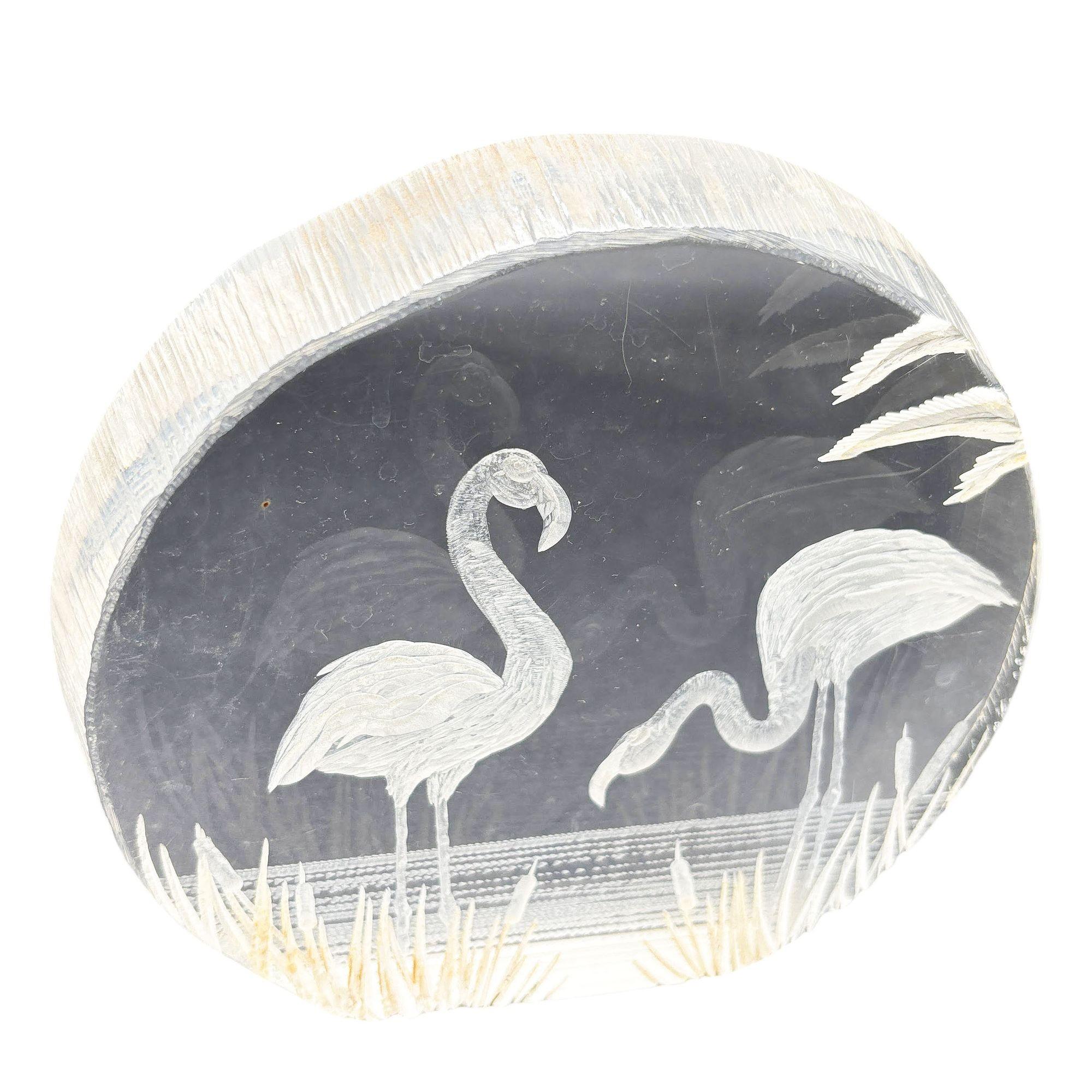 Modern 1980s flamingos in water, reverse carved lucite paperweight Sculpture. This lucite paperweight sculpture features a rounded shape with a hand-carved scene of flamingos resting on the beach during sunset.

Unsigned

Measurements: 4