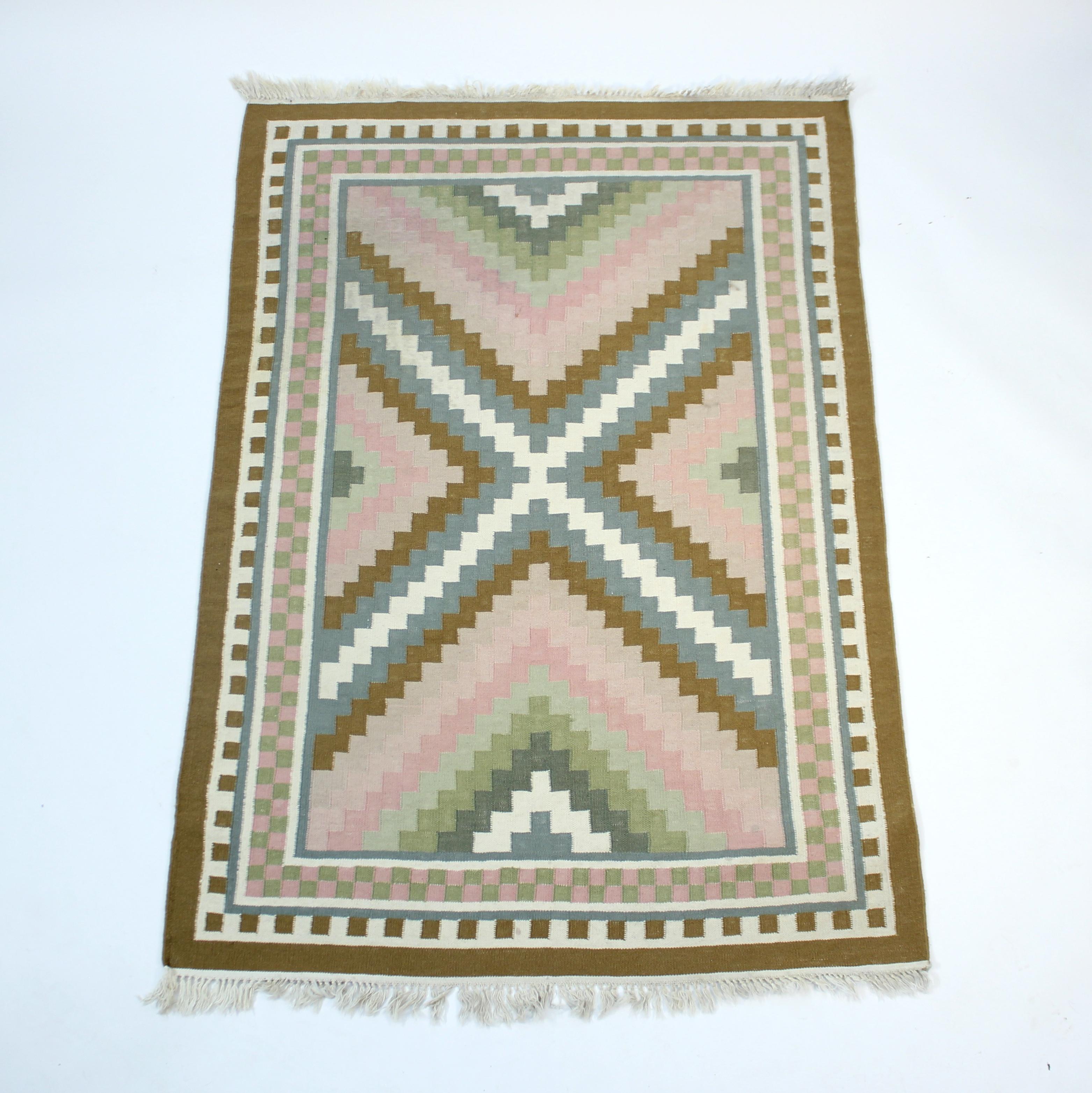 Tappeto Kelim a tessitura piatta degli anni 2000 di un designer sconosciuto. I colori principali sono il marrone, il rosa e il beige. Il motivo consiste in una cornice marrone e forme diverse in blu, rosa, verde e marrone su una base beige/marrone.