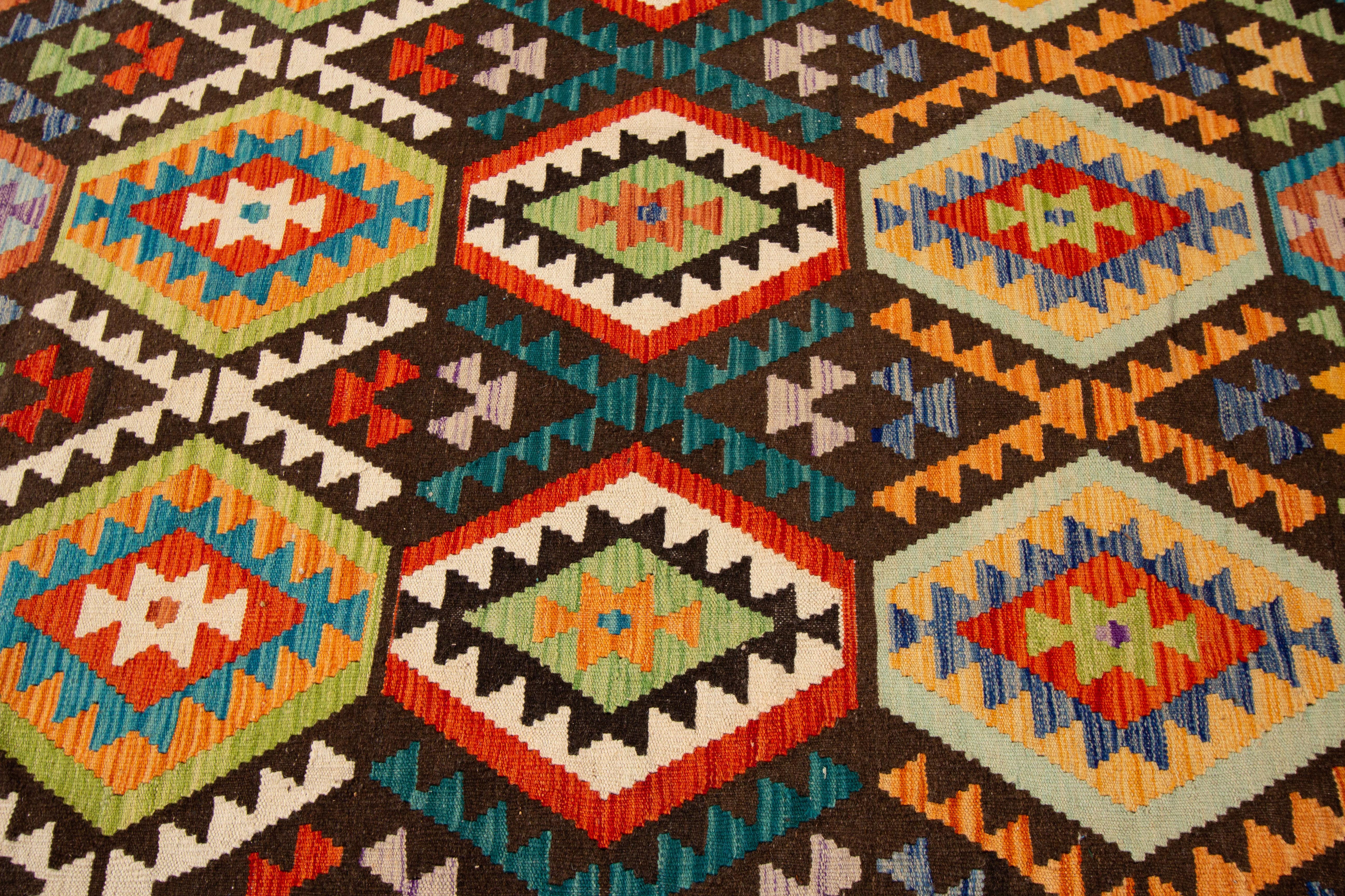 21st century contemporary handwoven Afghan Kilim with an all-over geometric motif. This piece has fine details, great colors, and a beautiful design. It would be the perfect addition to your home. Made with wool, measures 8'3